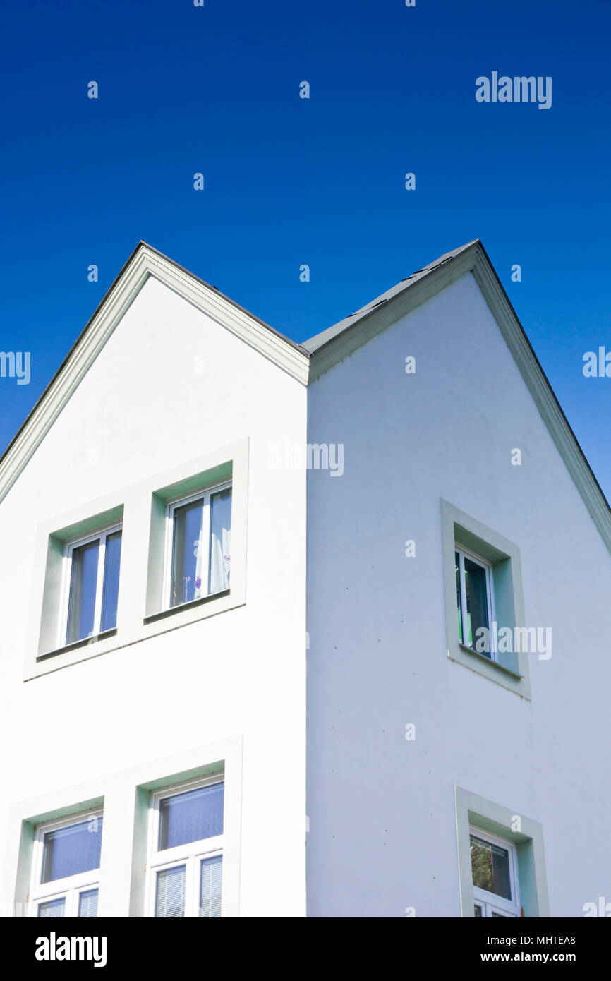 Wohnhaus mit Spitzdach vor blauem Himmel Stockfoto
