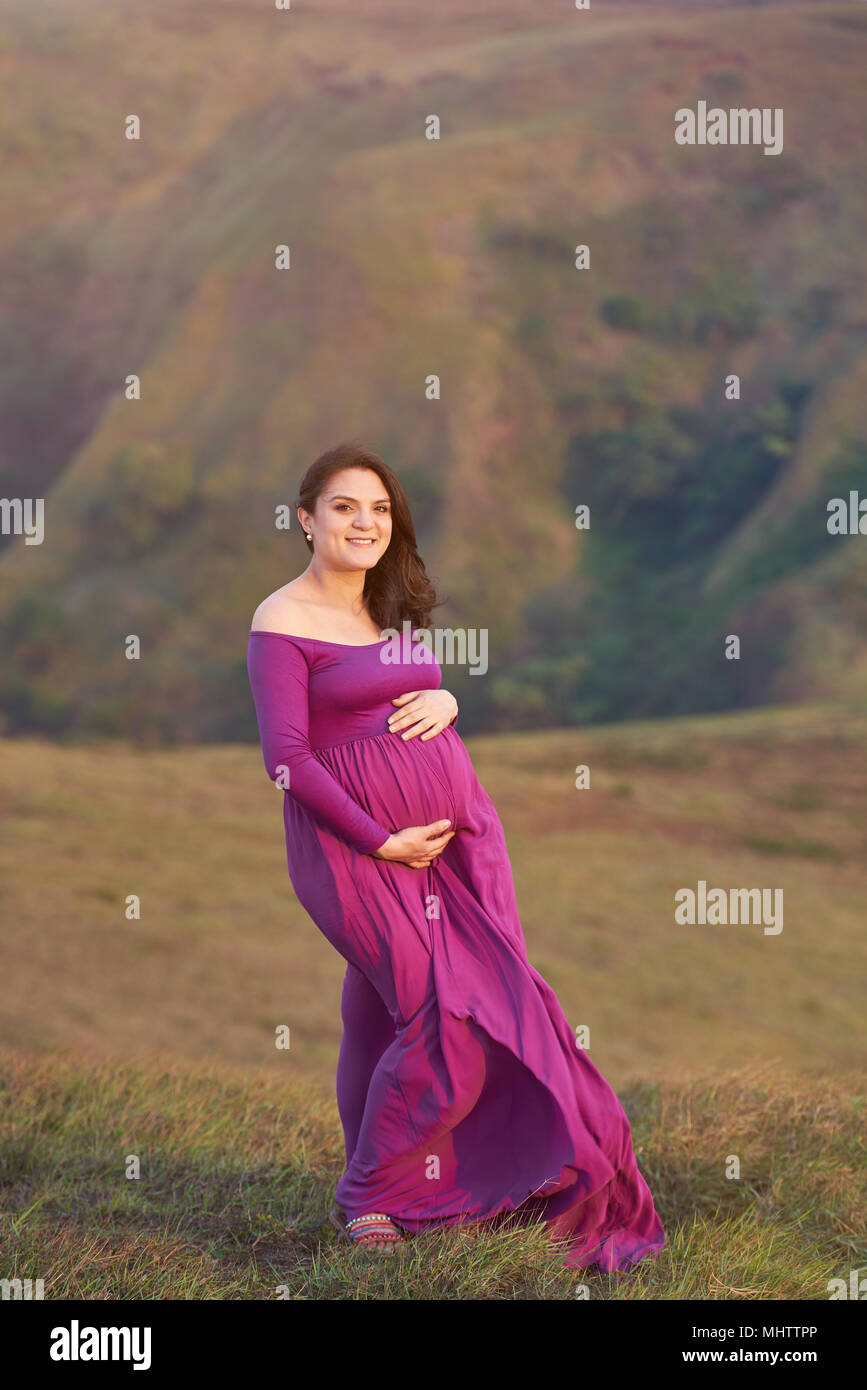 Hübsches Lächeln schwangere Frau umarmen Bauch Stockfoto