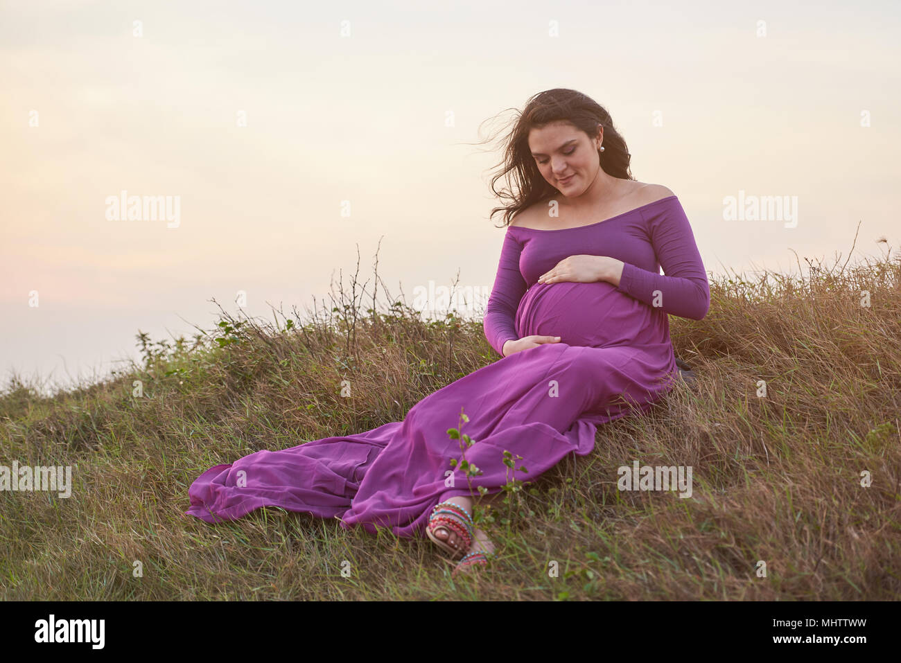 Junge schwangere Frau warten auf Baby in natürlichen Hintergrund Stockfoto