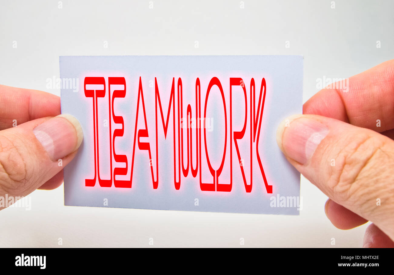 Man Hände halten eine Karte mit Teamarbeit Wort auf weißem Hintergrund Stockfoto
