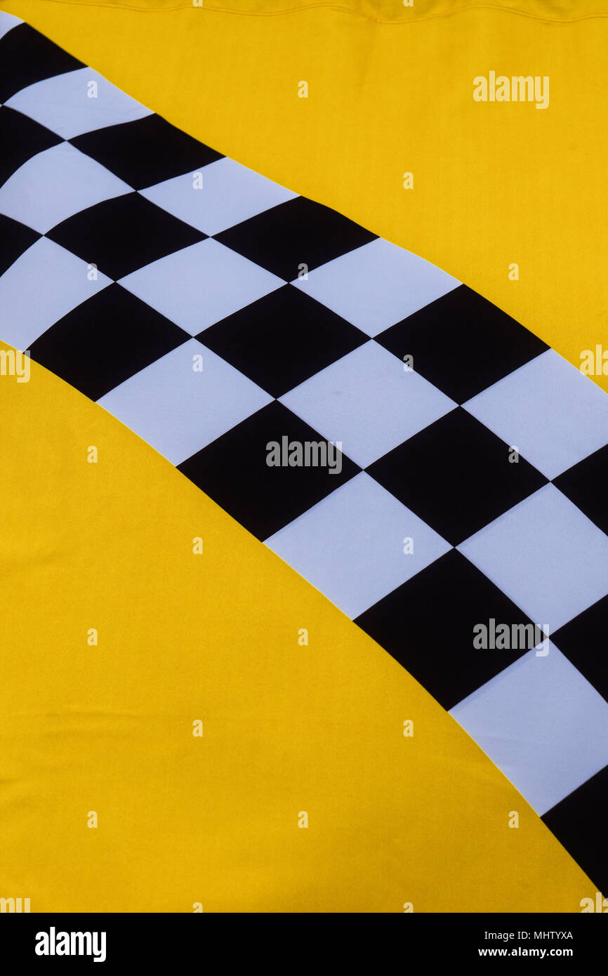 Details einer bunten mittelalterlichen Flagge. Gelbes Feld, diagonal schwarz-weiß karierten Mustern. Vertikale Foto Stockfoto