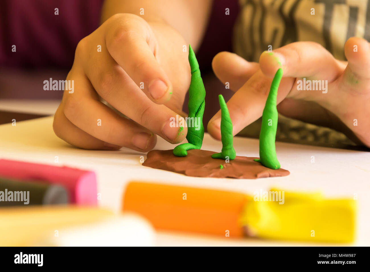 Kinder spielen mit Plastilin, Modellierung Baum. Die Entwicklung von Phantasie und Kreativität. Stockfoto