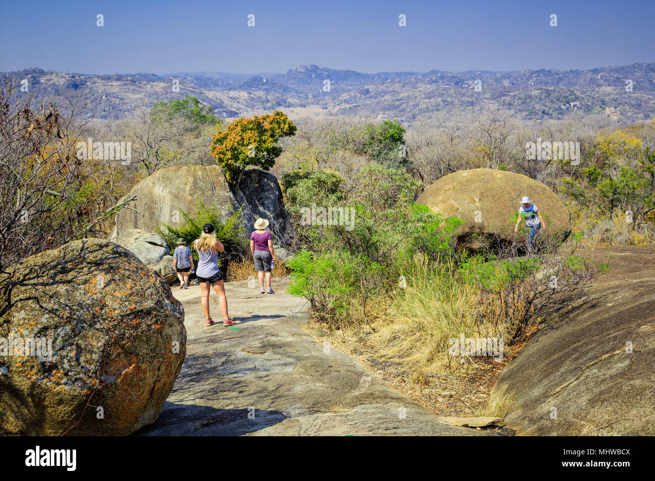 Touristen zu Fuß zwischen den Felsen im Matobo Nationalpark, Simbabwe. Stockfoto