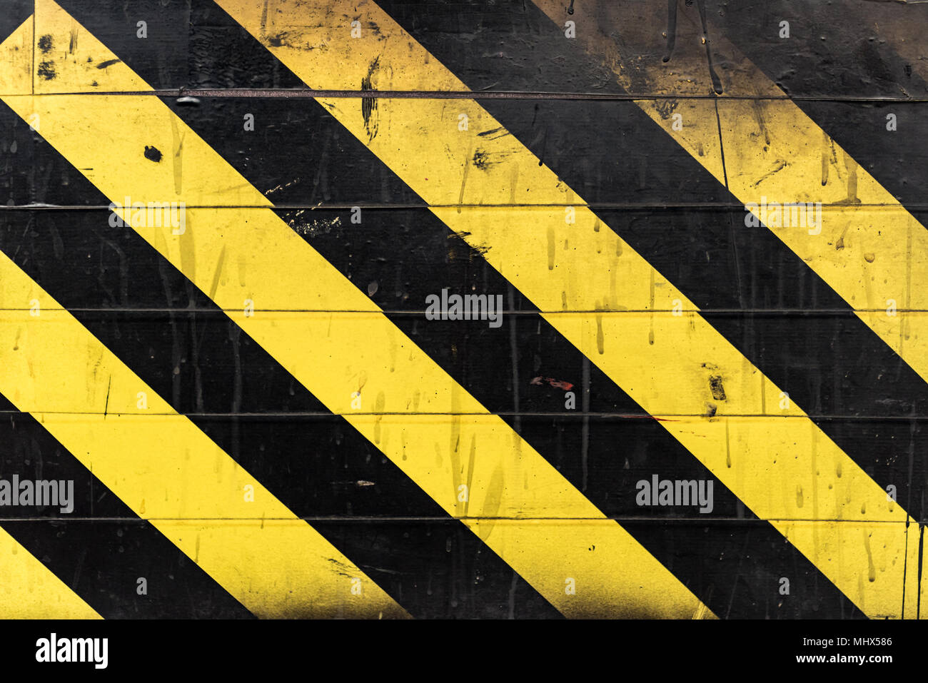 Textur der schwarzen und gelben Streifen an der Wand. Risiko oder Gefahr grungy Hintergrund. Stockfoto