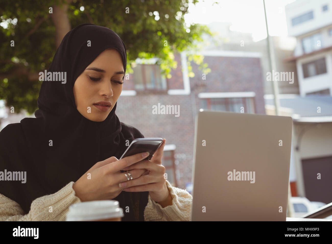 Hijab Frau mit Handy an Cafe Stockfoto