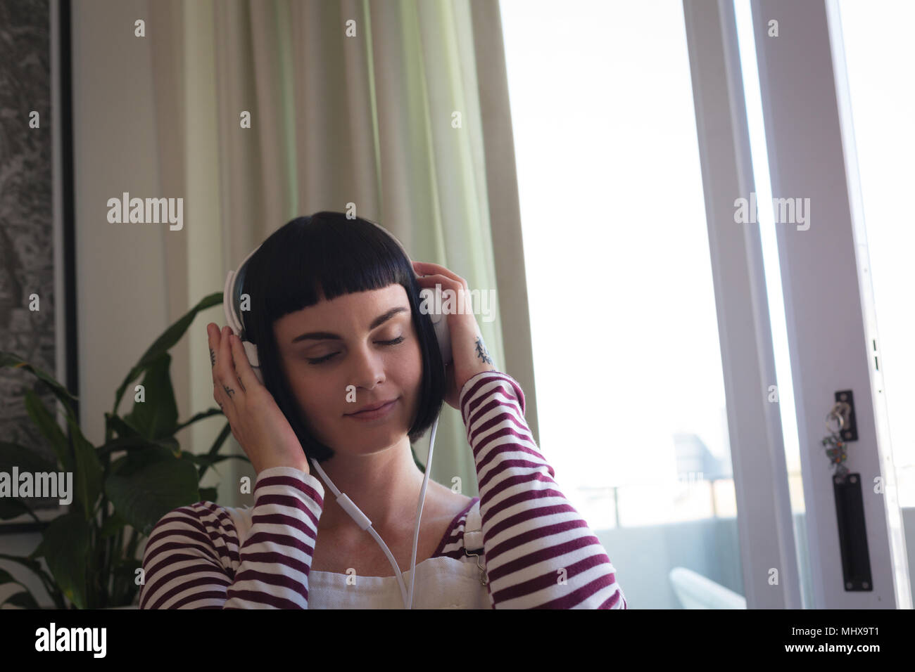 Frau Musik hören über Kopfhörer zu Hause Stockfoto