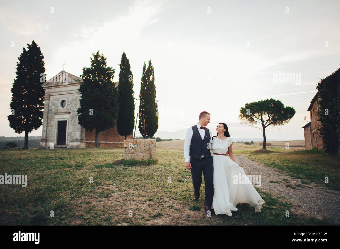 Gerne stilvolle lächelndes Paar wandern in der Toskana, Italien, am Tag ihrer Hochzeit. Stockfoto