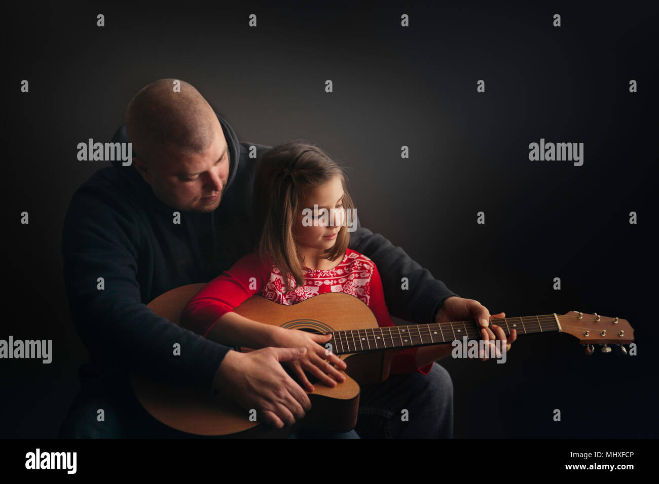 Vater Lehre Tochter, Gitarre zu spielen Stockfoto