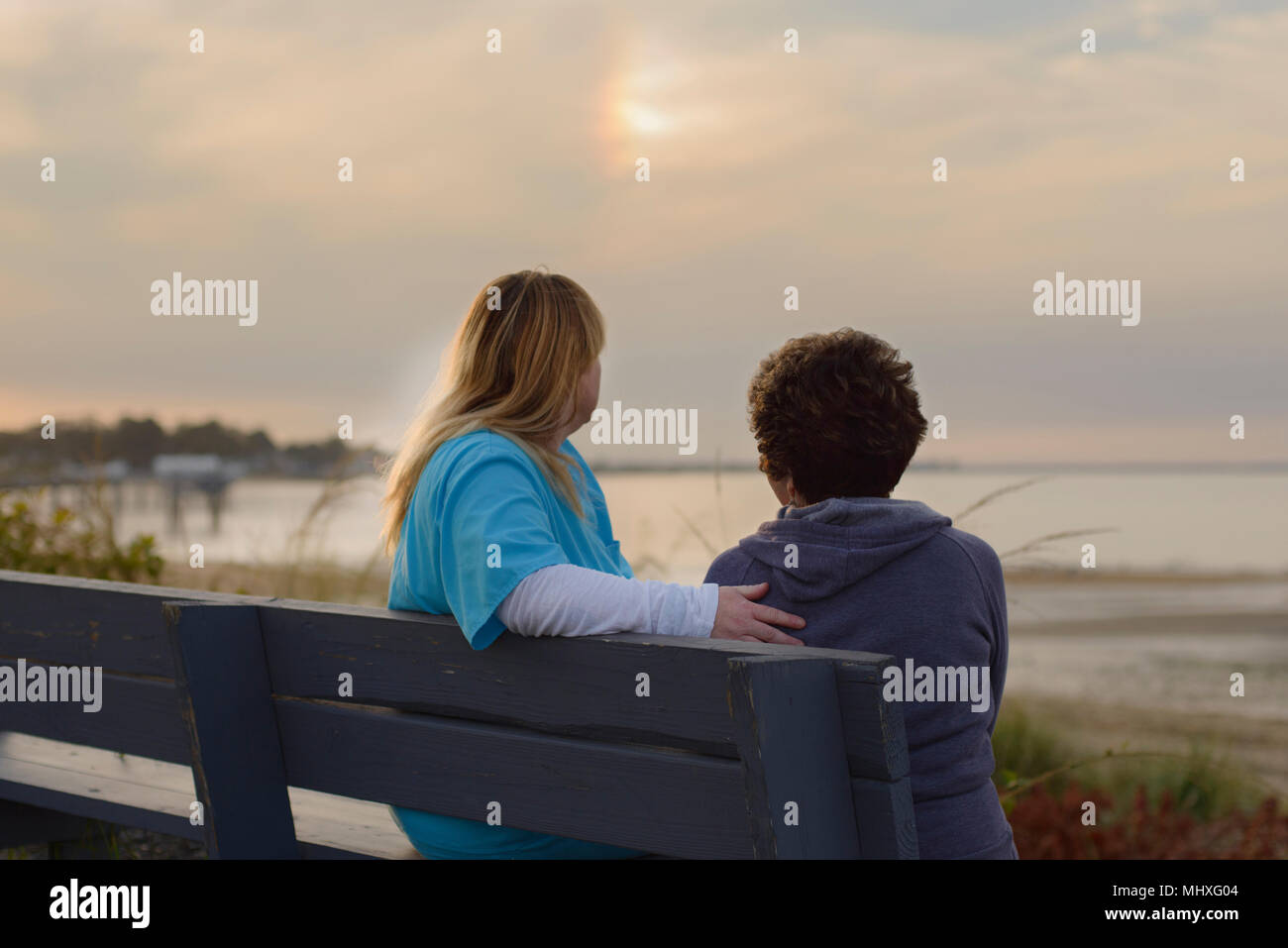 Frau und Pfleger genießen Abend Sonnenuntergang auf See Stockfoto