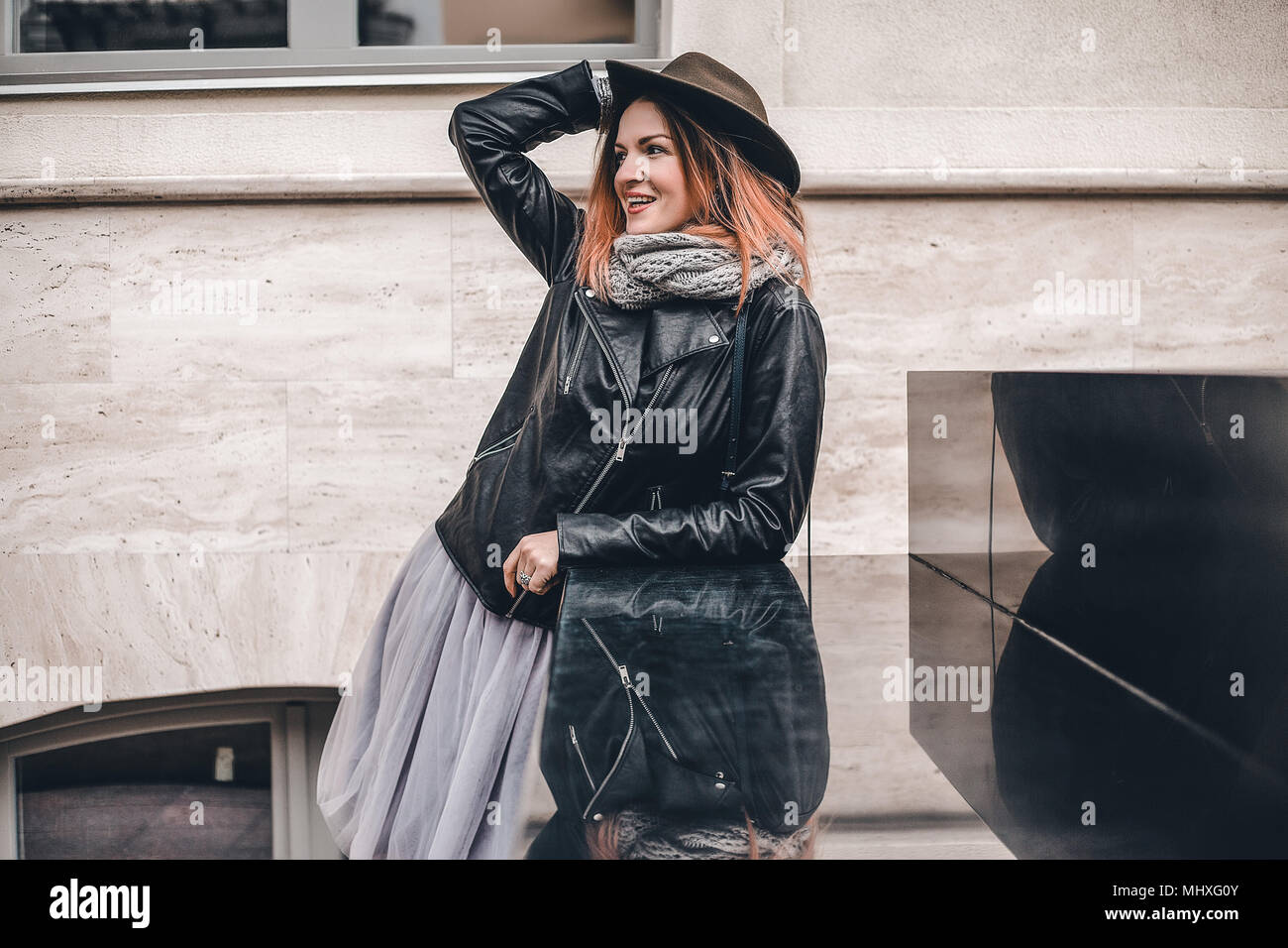 Frau mit Hut und Leder Jacke weg schauen Lächeln Stockfoto