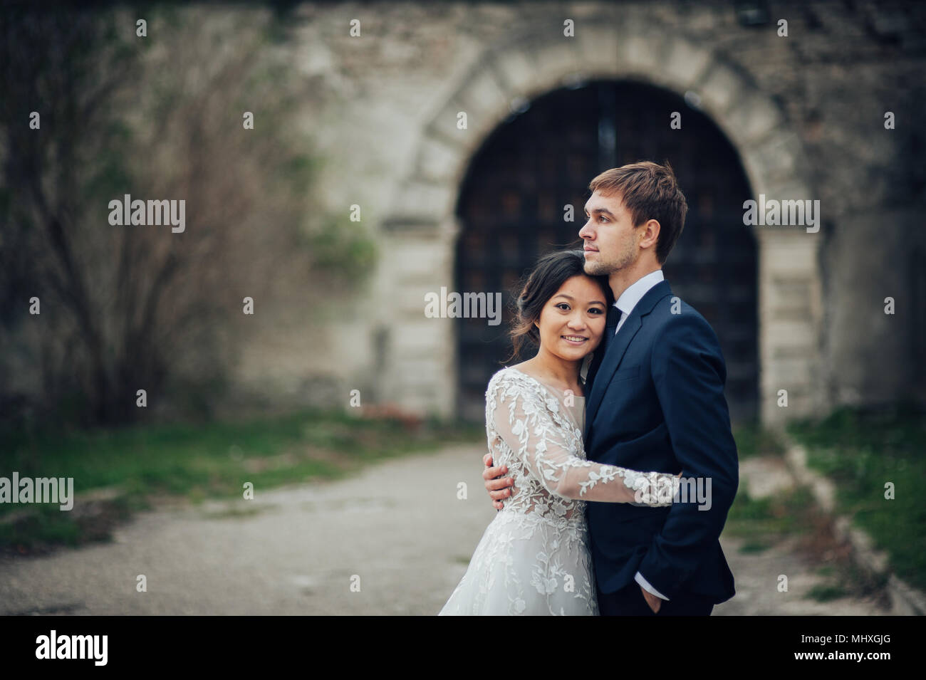 Elegante figurbetonte asiatische Braut Bräutigam in Schloss Hof Stockfoto