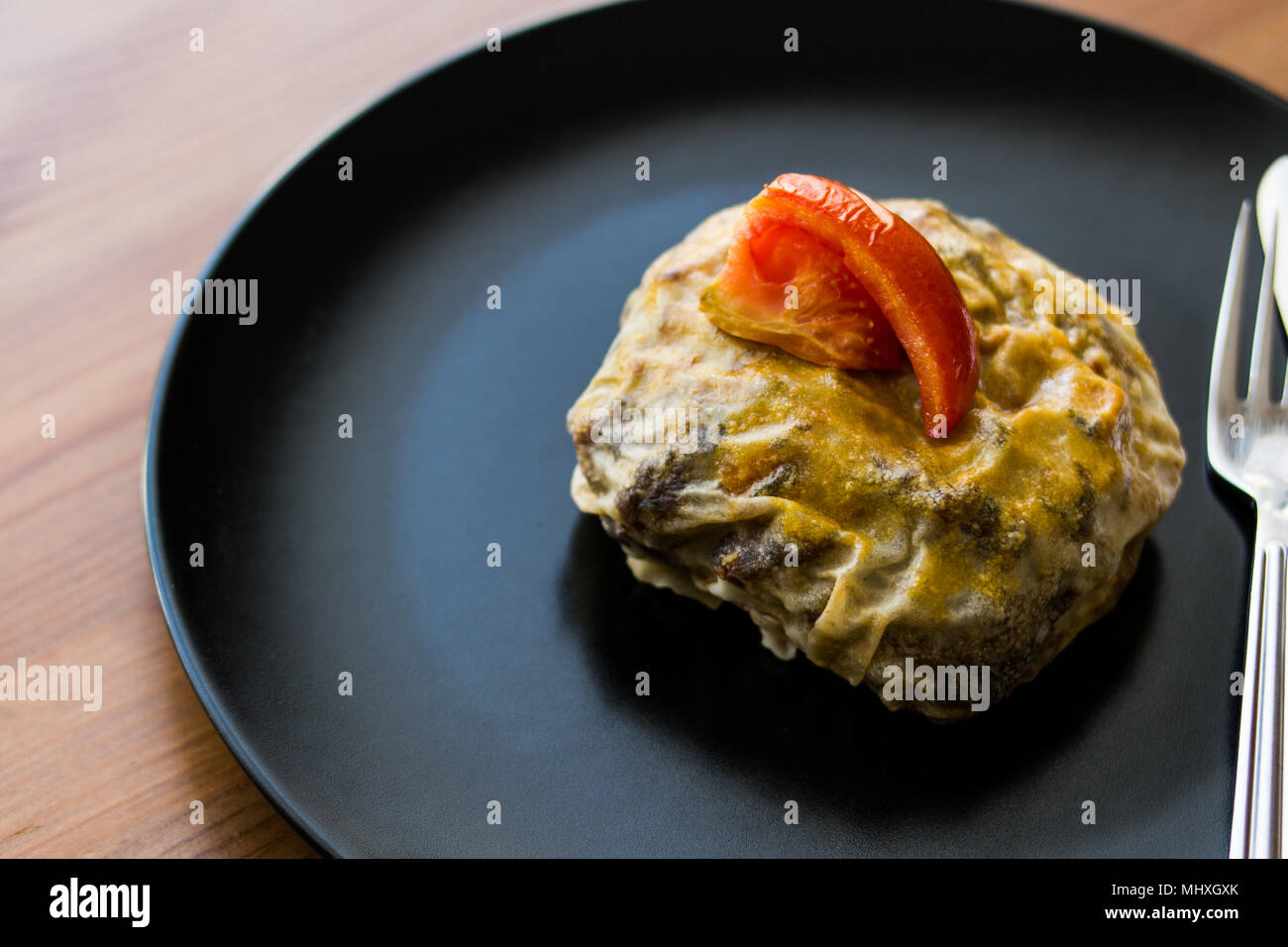 Türkische Bohca Kebab/Crepe mit Cubed Meatball und Gemüse auf einem Holz- Oberfläche. Stockfoto