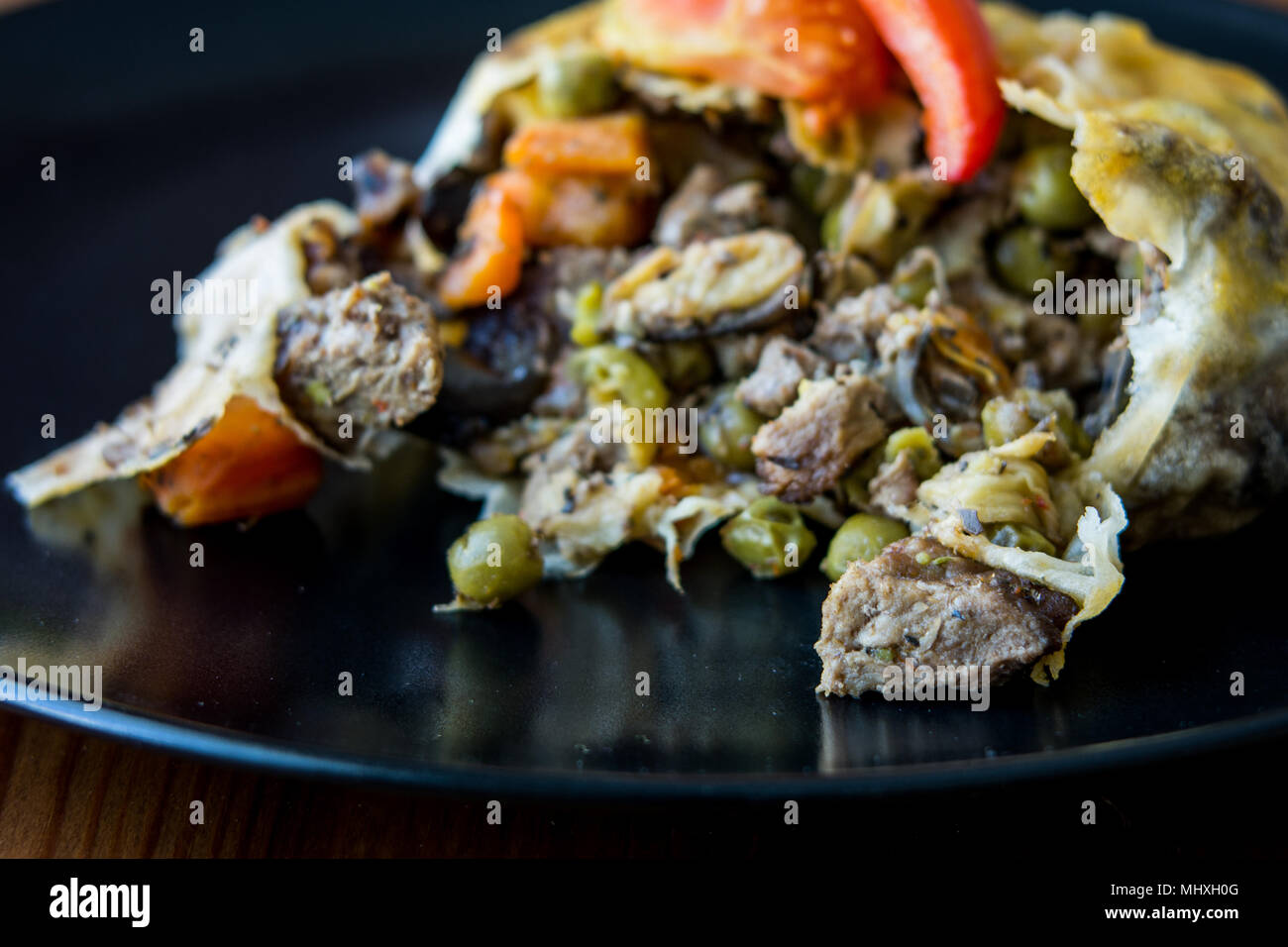 Türkische Bohca Kebab/Crepe mit Cubed Meatball und Gemüse auf einem Holz- Oberfläche. Stockfoto
