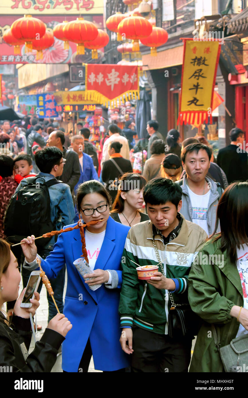 Die Einheimischen essen Spieße und andere Fast Food, Wangfujing Snack Street, Dongcheng District, Beijing, China Stockfoto