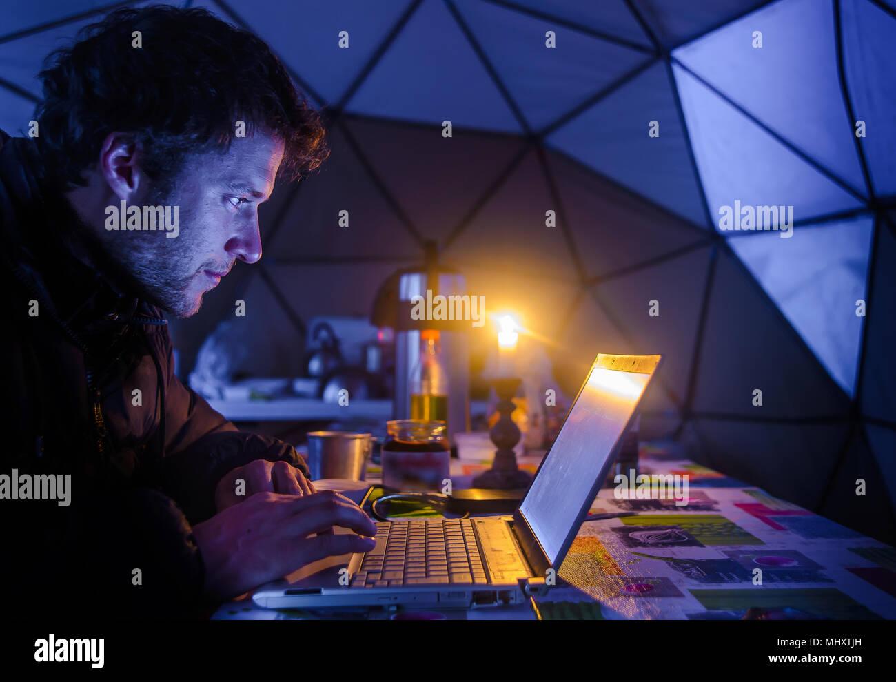 Mann auf Expedition, mit Laptop im Lager, Fletanes Camp, Narsaq, Kitaa, Grönland Stockfoto