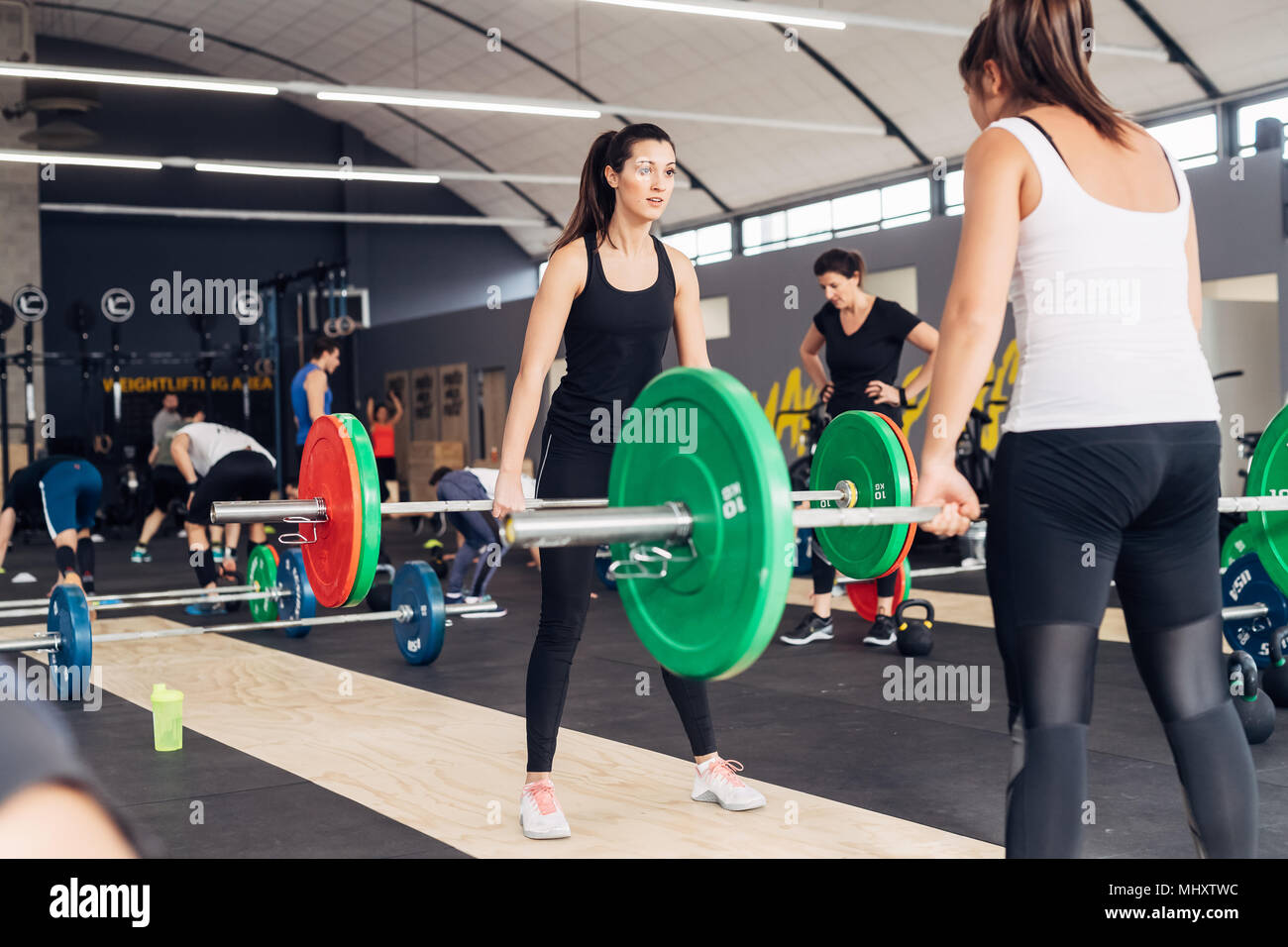 Frauen Gewichtheben mit Hanteln in der Turnhalle Stockfoto