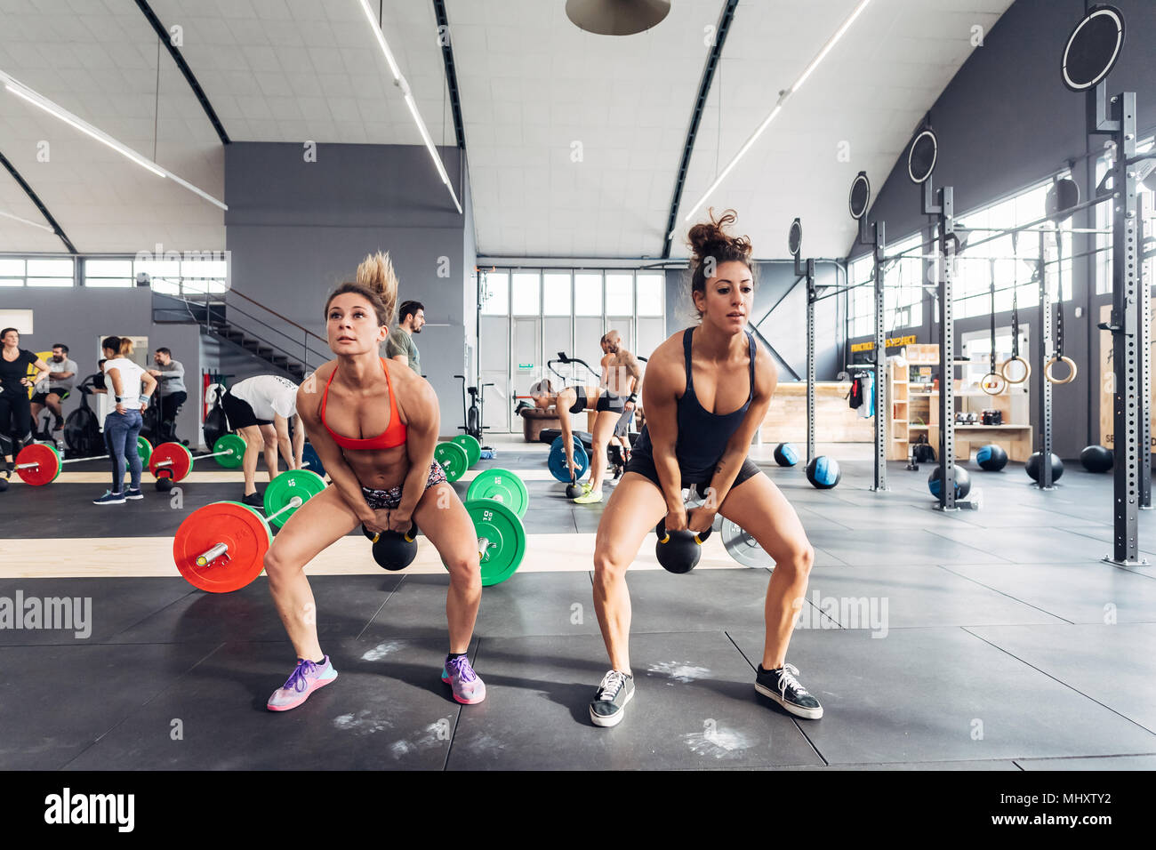 Frauen Training im Fitnessraum mit Wasserkocher Glocken Stockfoto