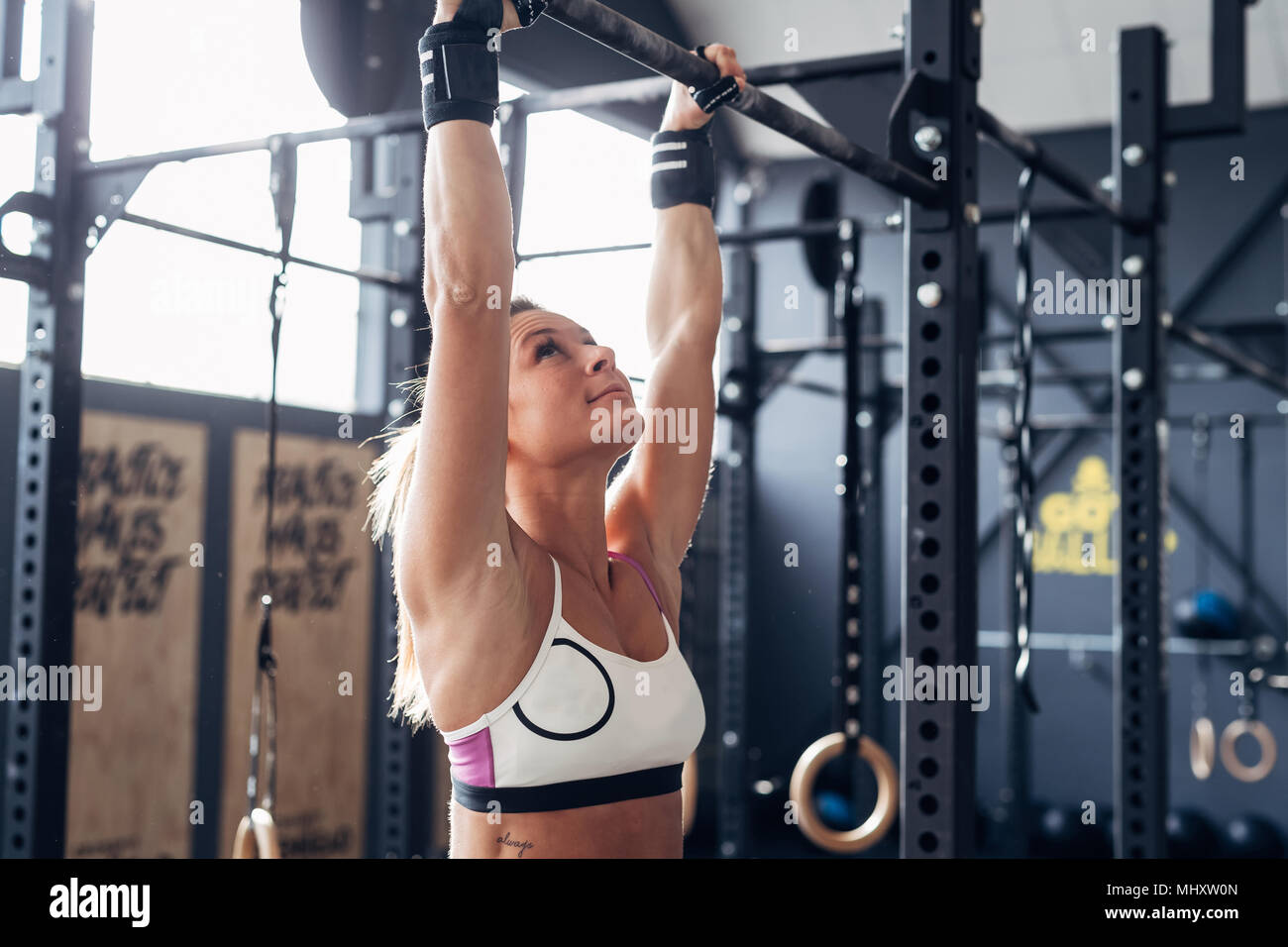 Frau mit Chin Up Bar in der Turnhalle Stockfoto