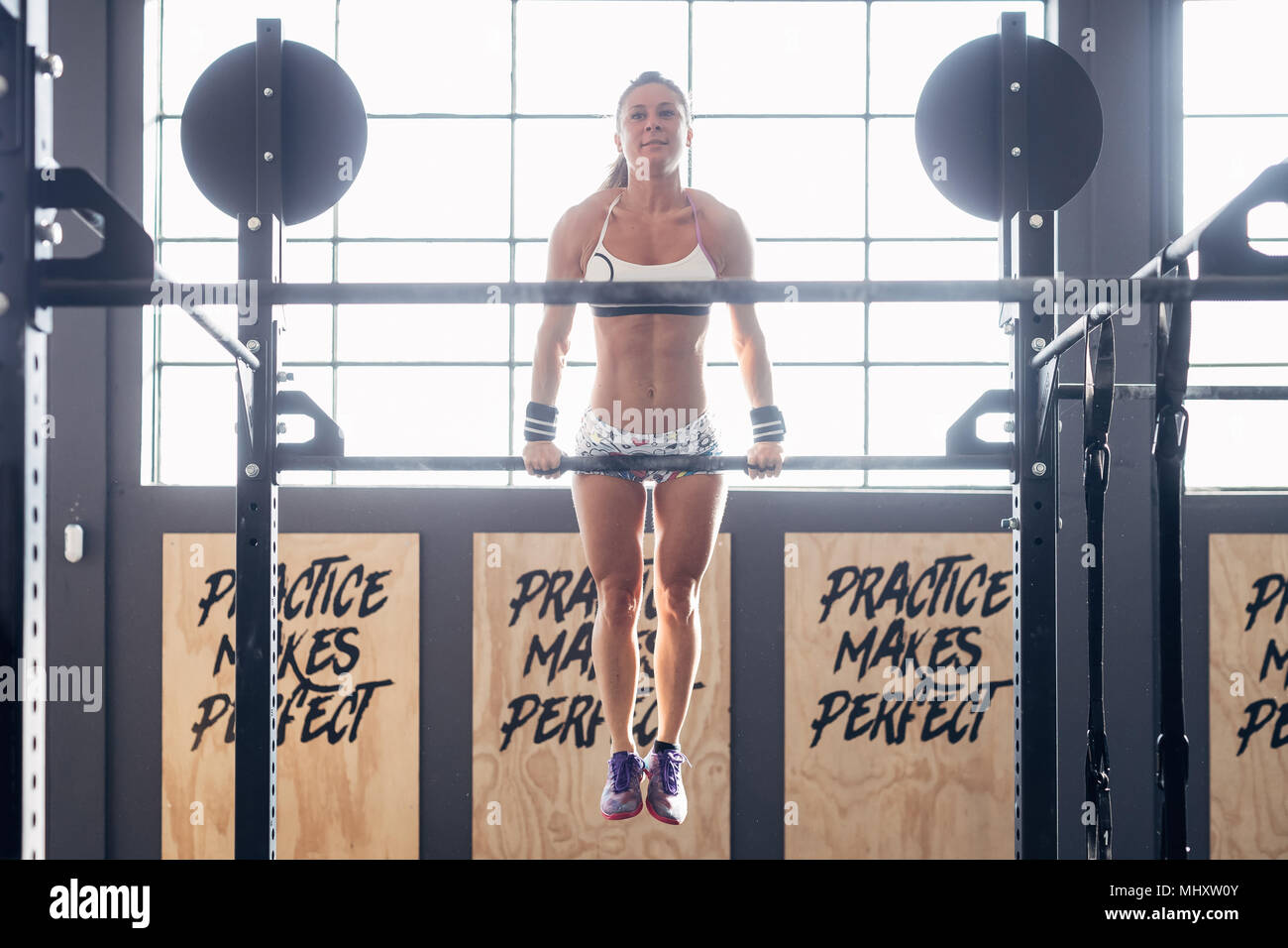 Frau mit Chin Up Bar in der Turnhalle Stockfoto