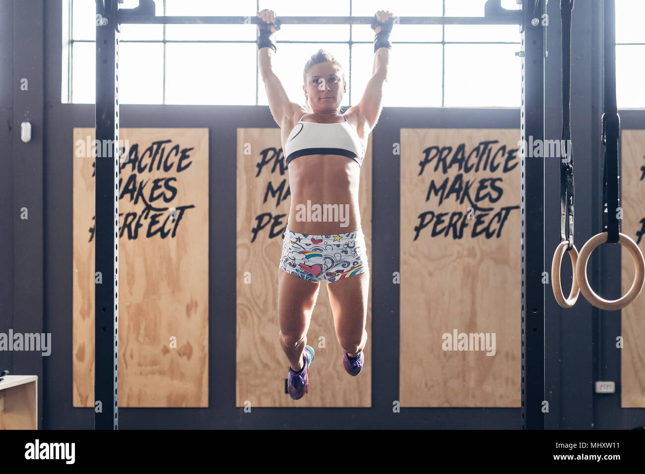 Frau mit Chin Up Bar in der Turnhalle Stockfoto