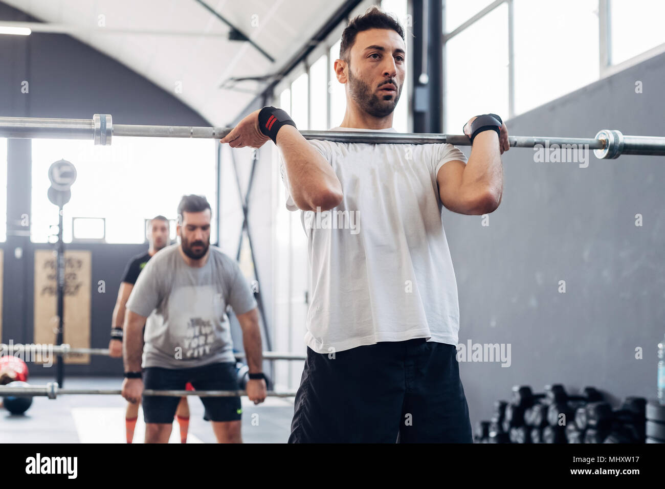 Mann Gewichtheben mit Barbell in der Turnhalle Stockfoto