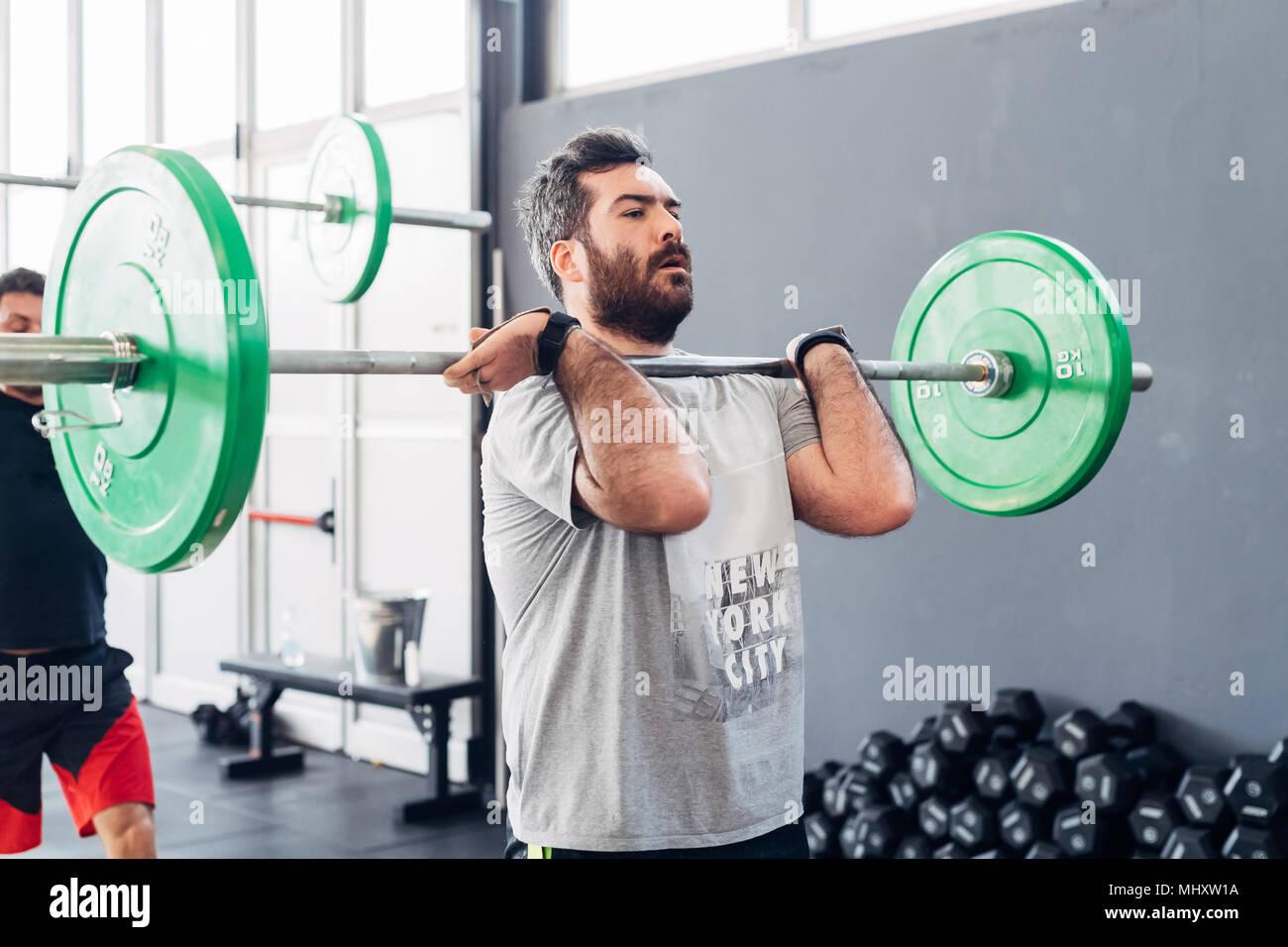 Mann Gewichtheben mit Barbell in der Turnhalle Stockfoto