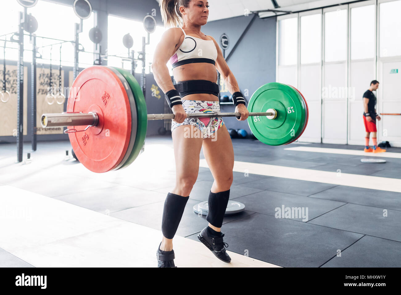 Frau weightlifting Barbell in der Turnhalle Stockfoto