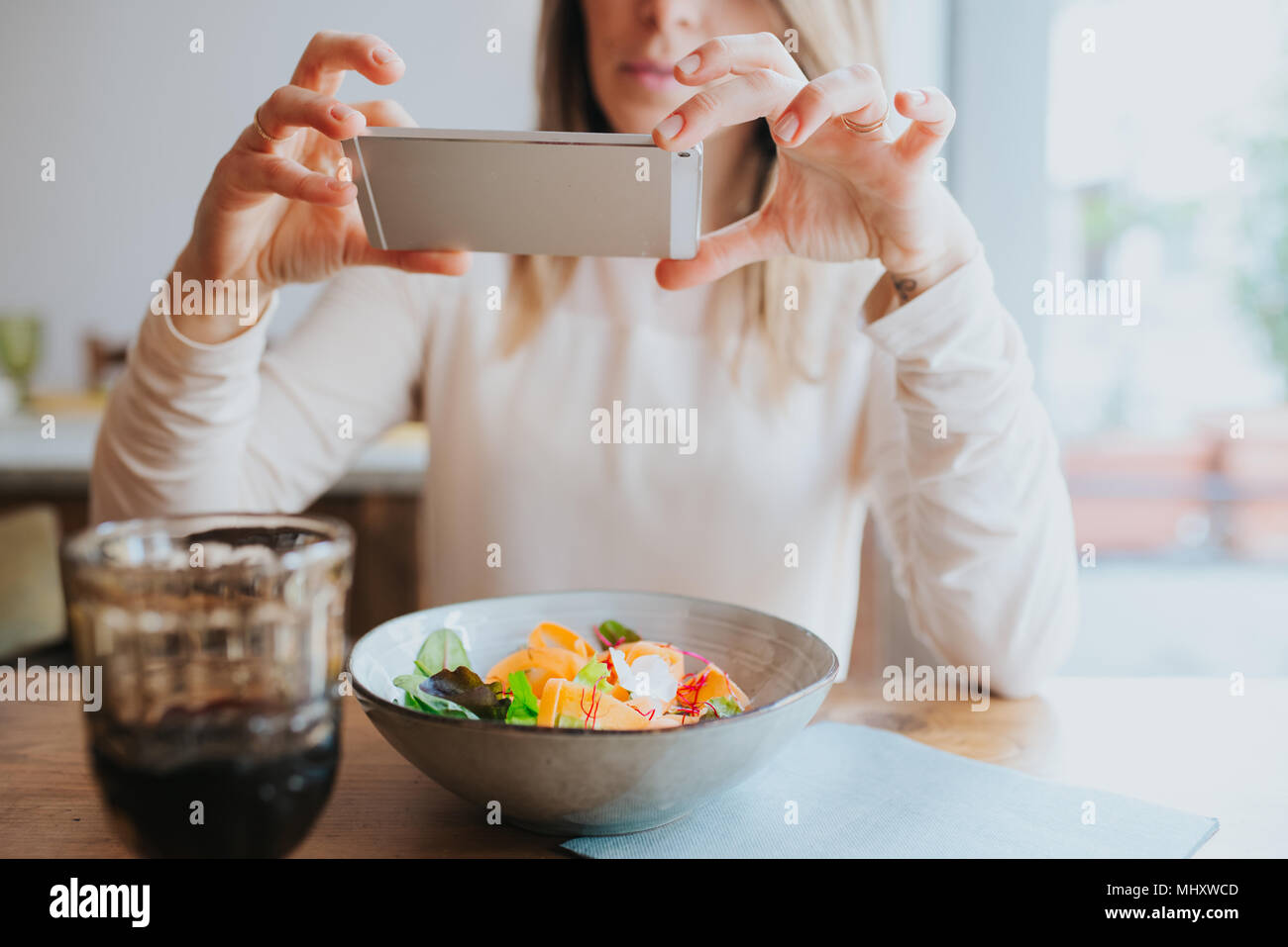 Frau unter Foto von vegane Mahlzeit im Restaurant Stockfoto