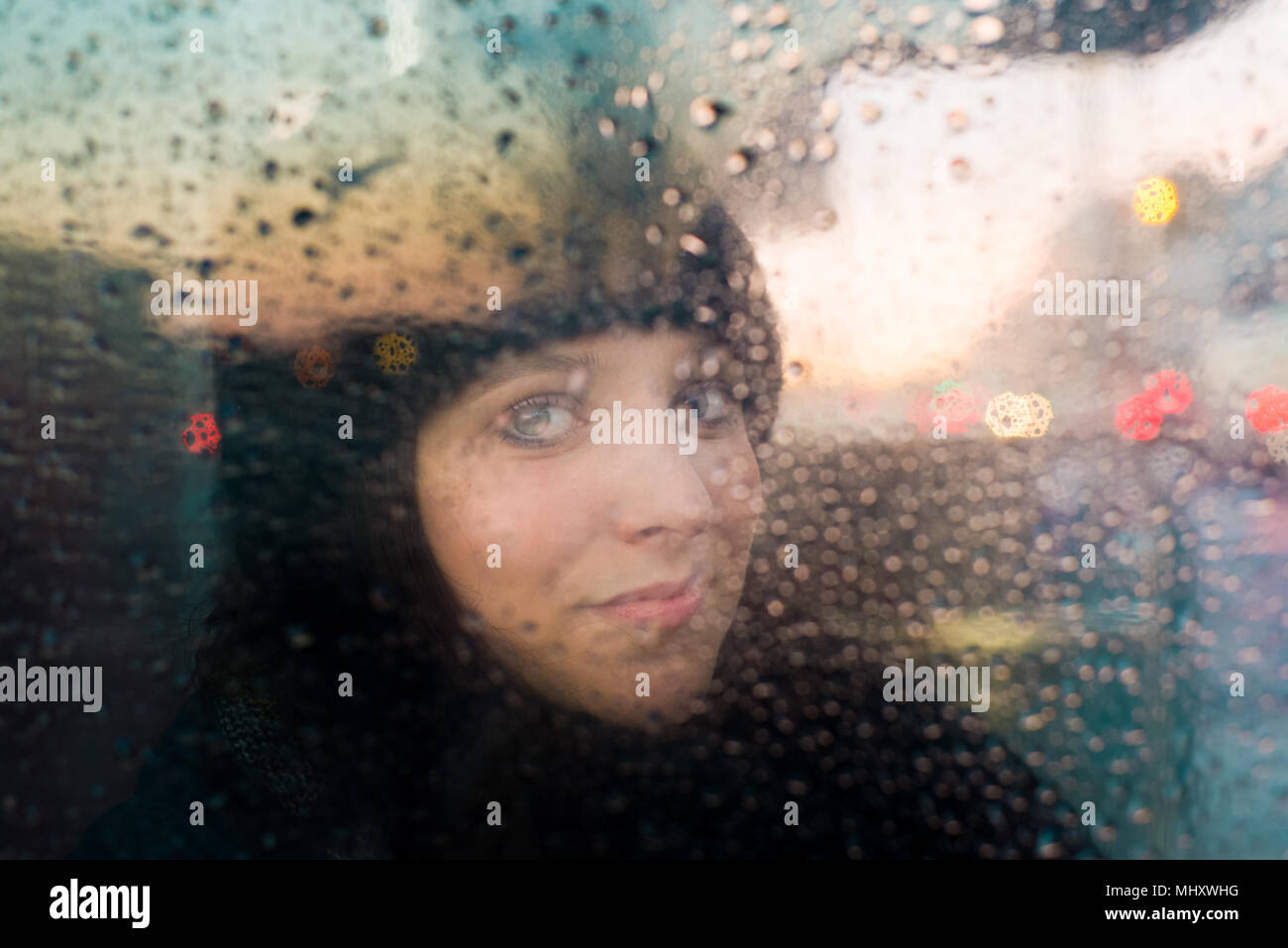 Frau Suchen aus Regen spritzte Fenster Stockfoto