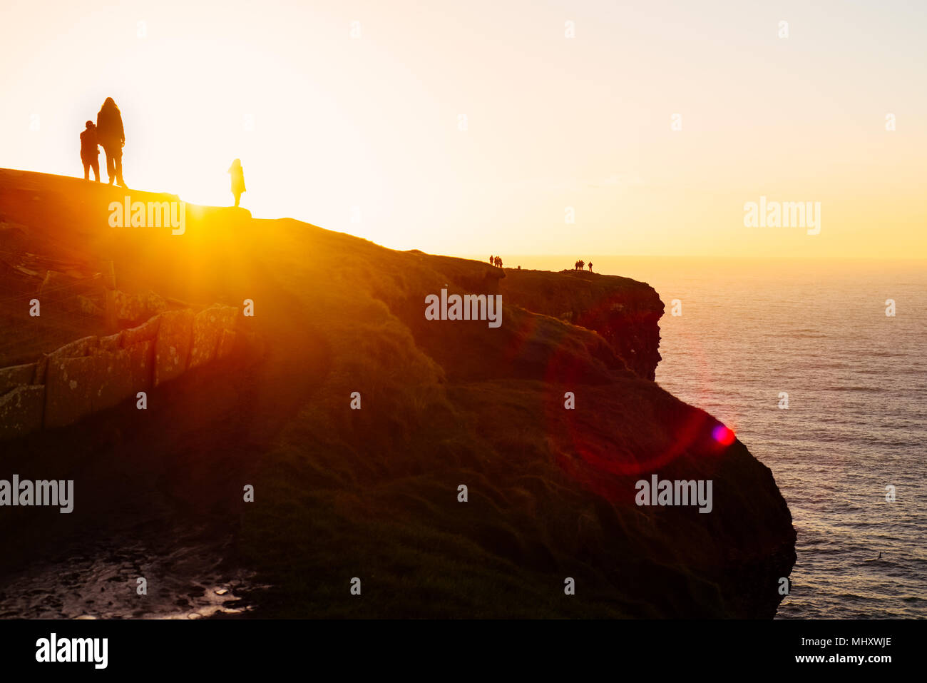 Leute an den Klippen beobachten, Sonnenuntergang, Liscannor, Clare, Irland Stockfoto