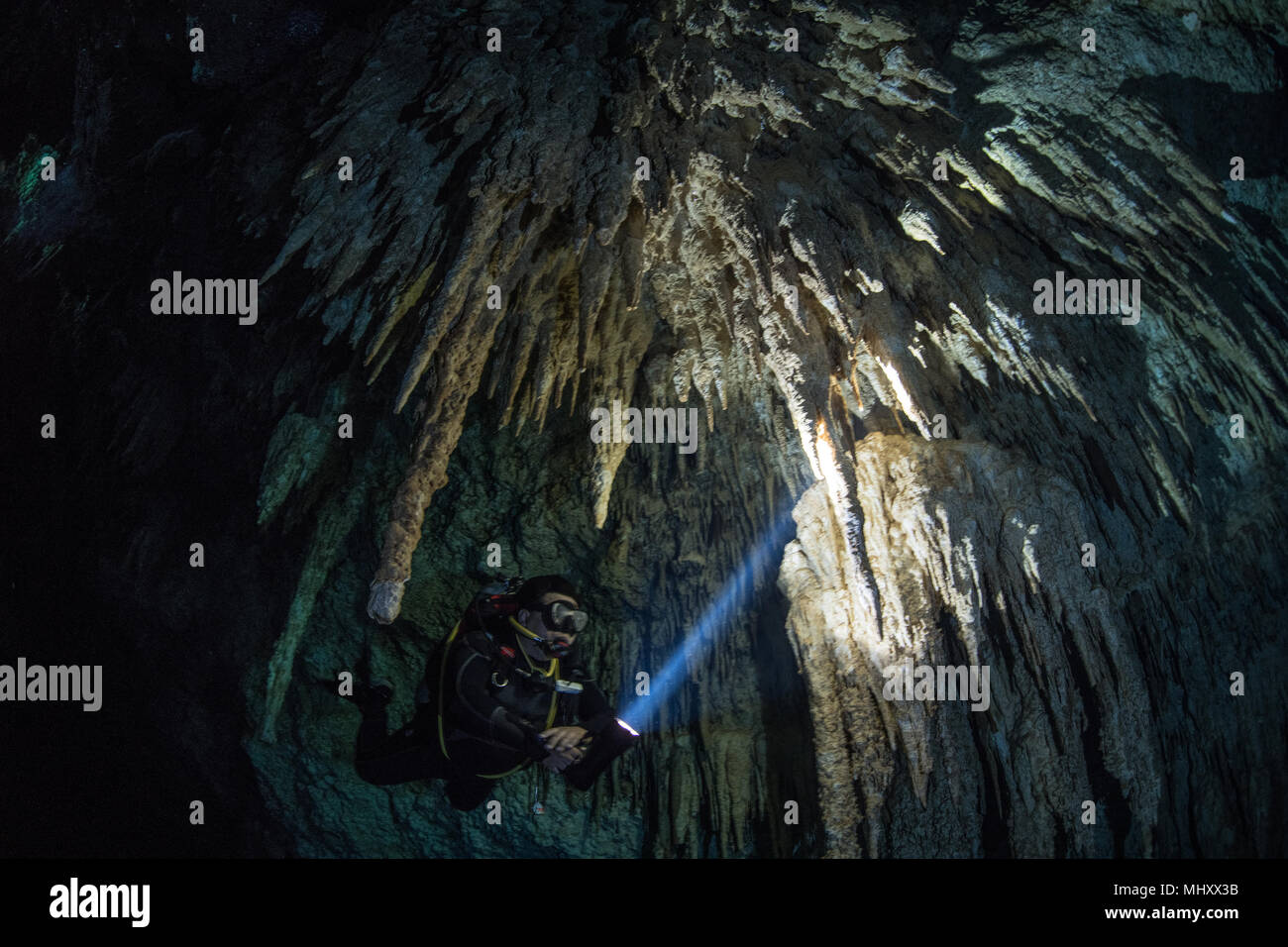 Männliche Taucher tauchen im unterirdischen Fluss (CENOTE) mit Stalaktiten Felsformationen, Tulum, Quintana Roo, Mexiko Stockfoto