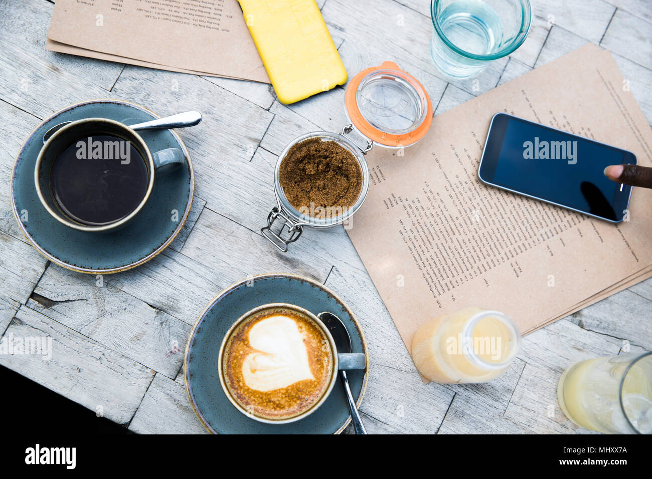 Kaffee, Mobiltelefon, Menü auf hölzernen Tisch Stockfoto