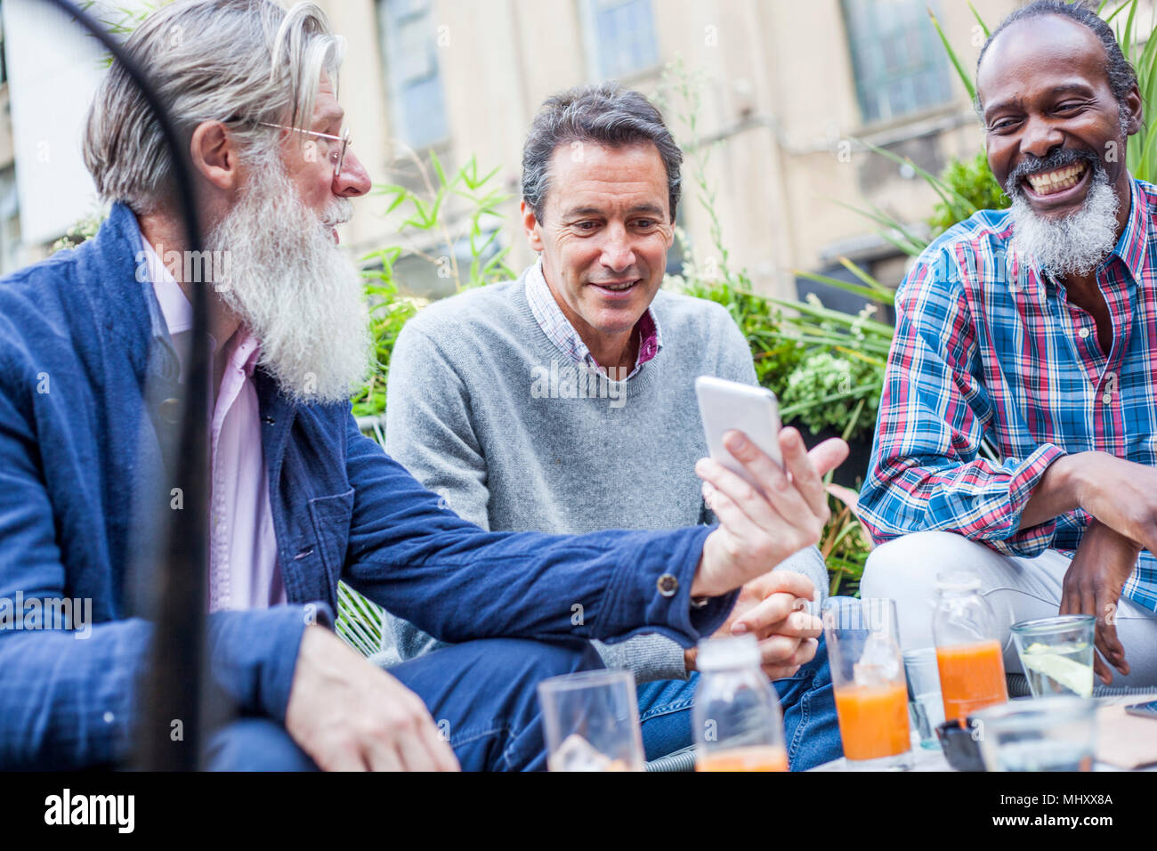 Freunde lesen Sms draussen, London, UK Stockfoto