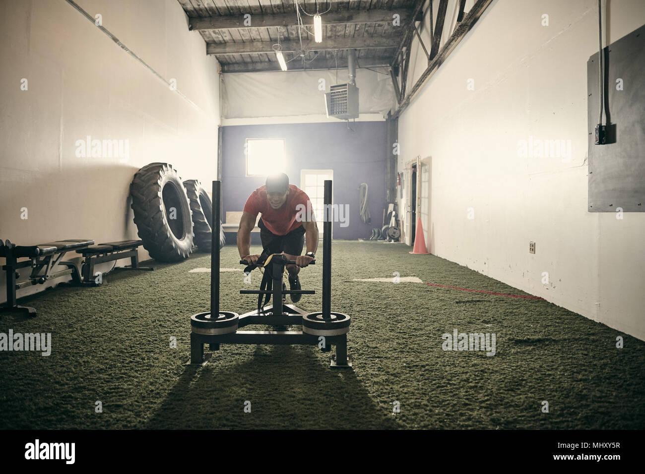 Mann im Fitnessraum mit Trainingsgeräten Stockfoto