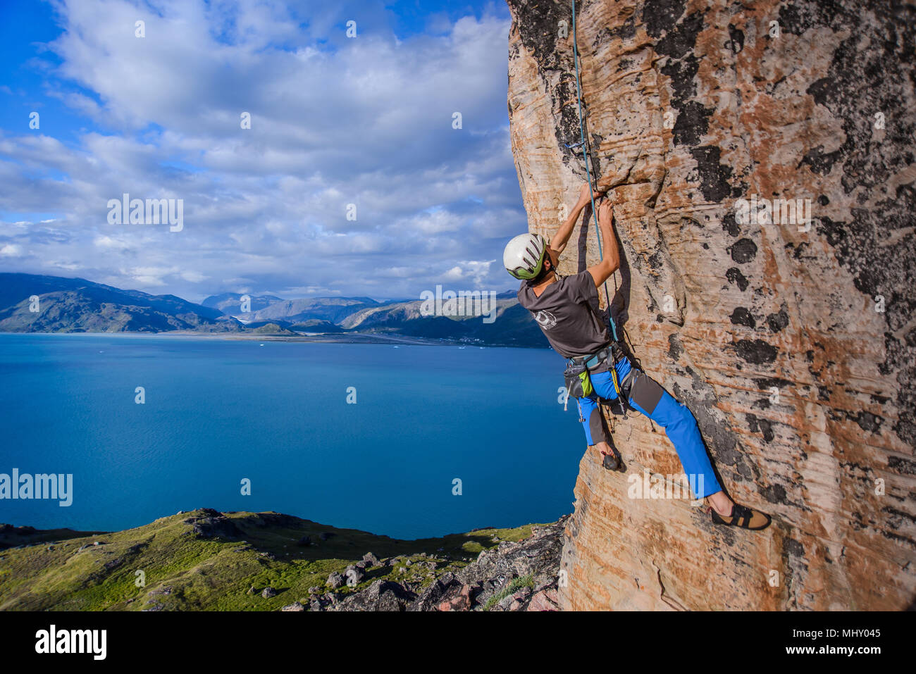 Junge männliche Kletterer klettern Sandstein Felswand, Narsaq, Vestgronland, Südgrönland Stockfoto
