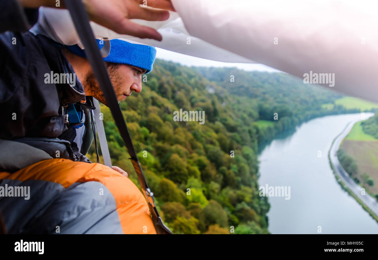 Junge männliche Kletterer in Felswand portaledge an Maas, Freyr, Belgien sucht, Erhöhte Ansicht Stockfoto