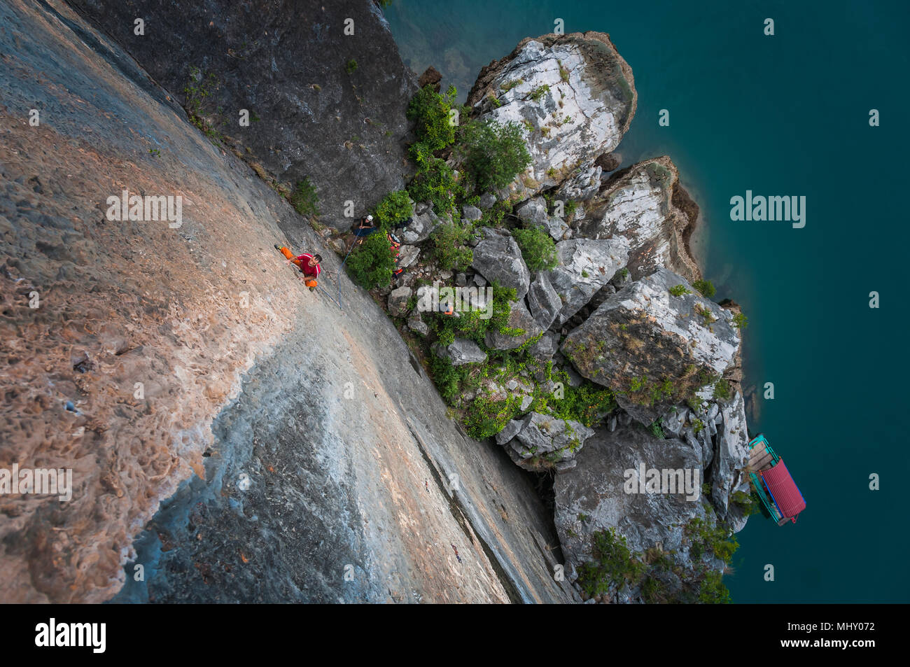 Man Klettern auf Kalkfelsen, Ansicht von oben, Ha Long Bay, Vietnam Stockfoto