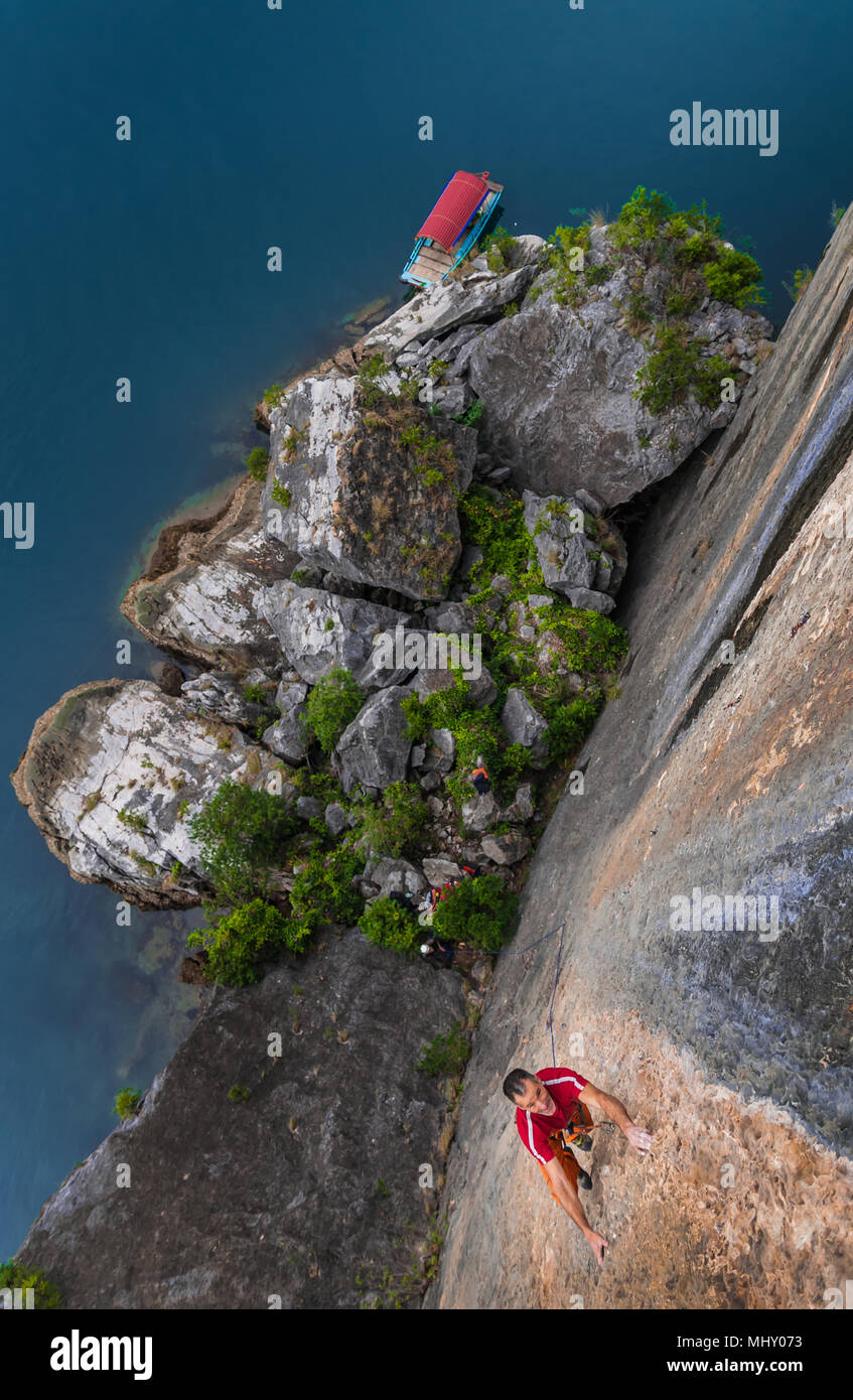 Man Klettern auf Kalkfelsen, Ansicht von oben, Ha Long Bay, Vietnam Stockfoto