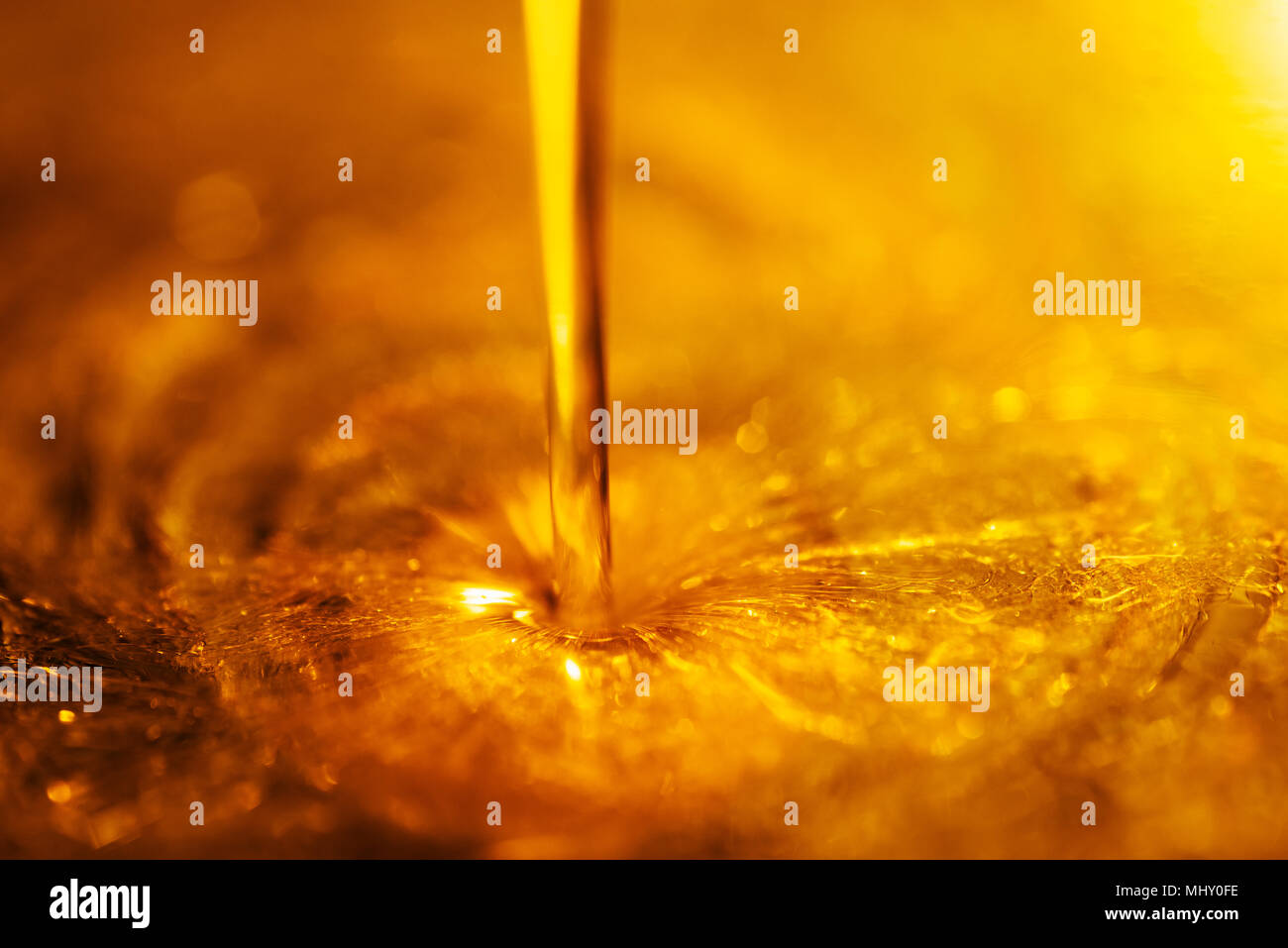 Orange flüssige und viskose Strom von Motorrad Motor Öl wie ein Fluss von Honig close-up Stockfoto