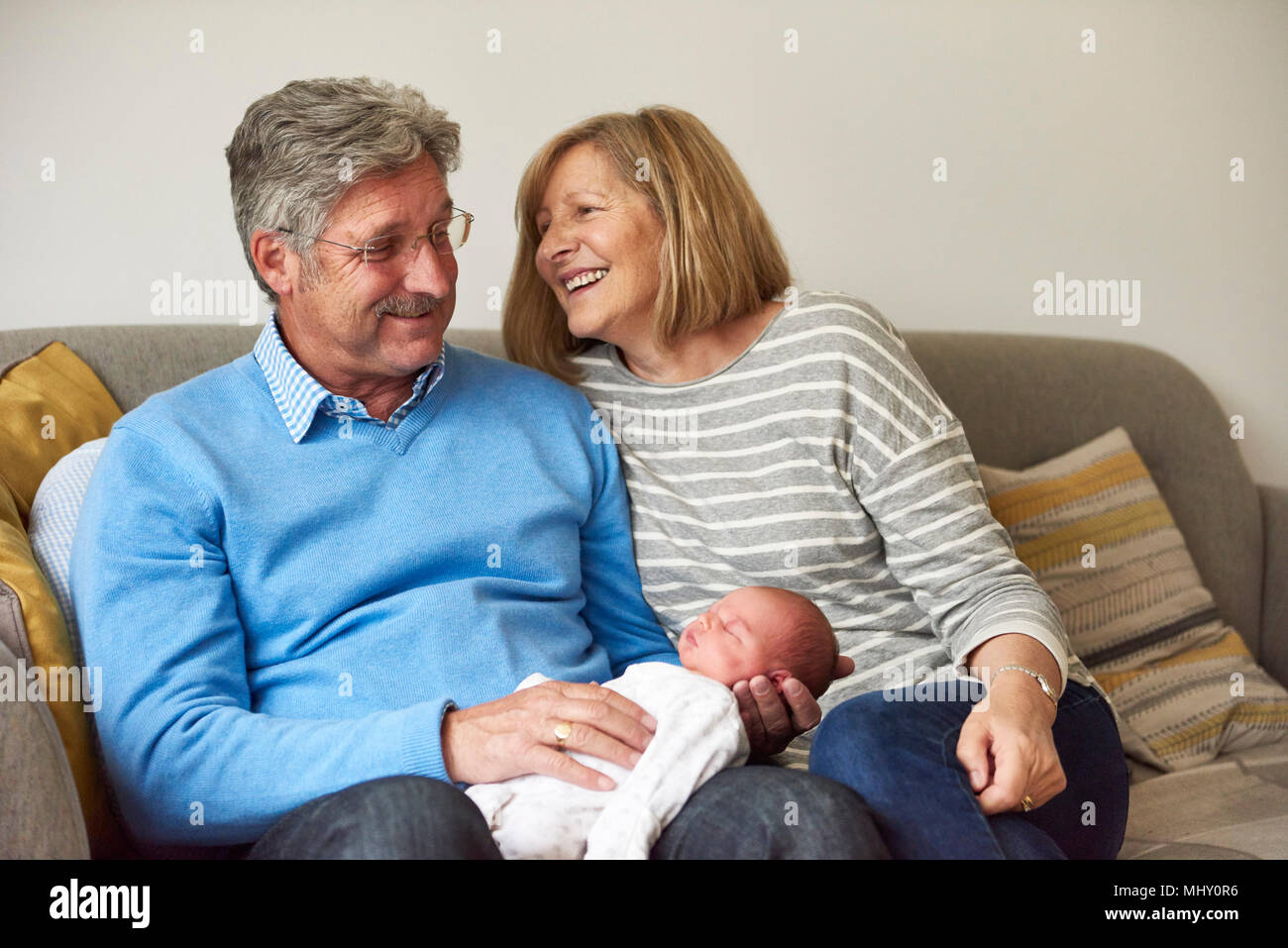 Großeltern auf dem Sofa mit Baby Enkelin Stockfoto