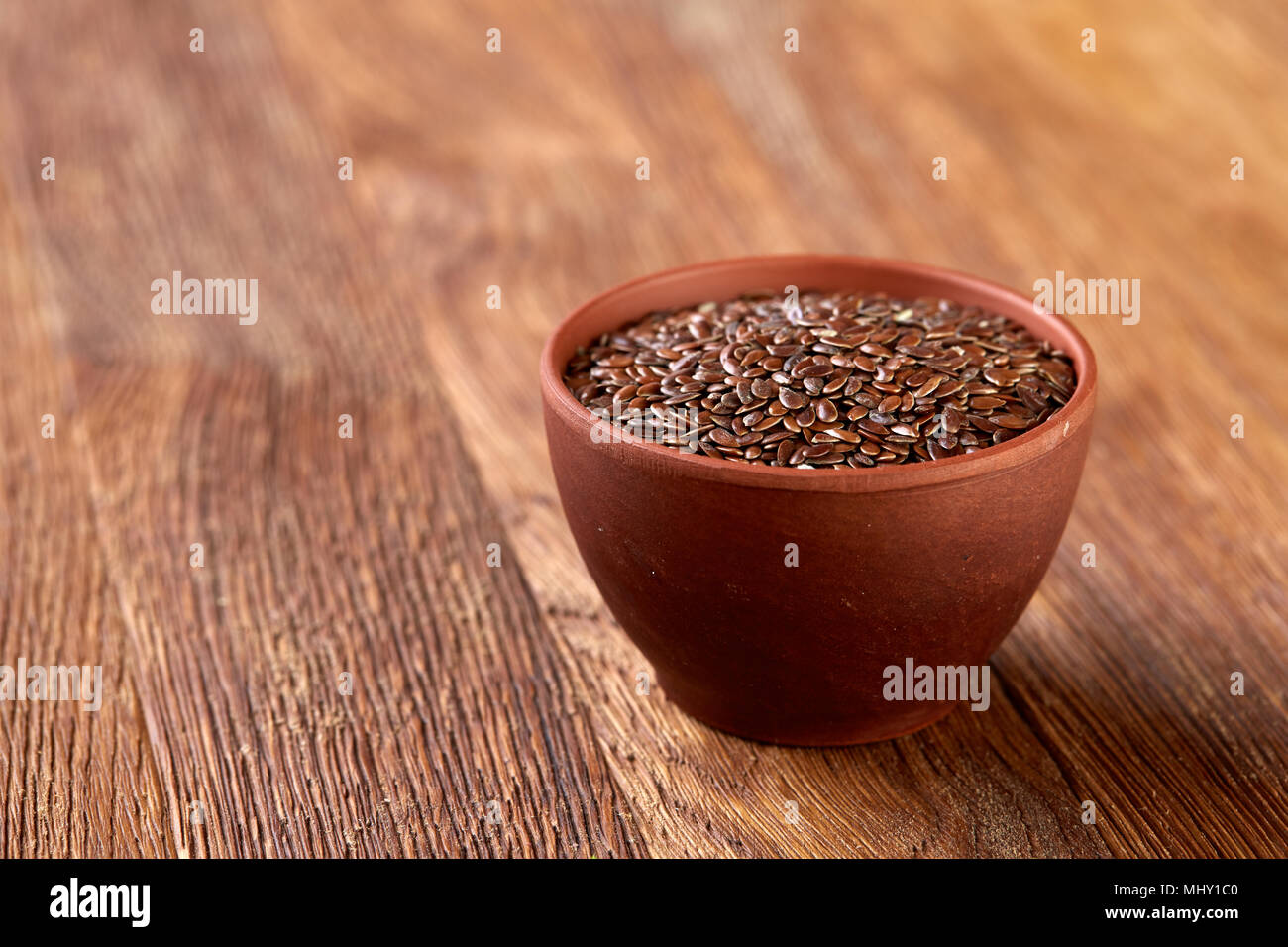 Ansicht von oben Nahaufnahme von Leinsamen in Houten auf Braun rustikal Hintergrund isoliert, selektiver Fokus, senkrecht. Nahrhaft und deitary I Stockfoto