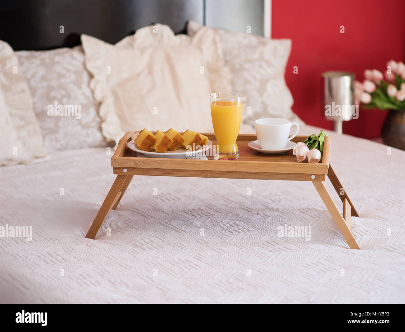 Frühstück im Bett ein Glas Orangensaft und einen Keks mit Kaffee Stockfoto