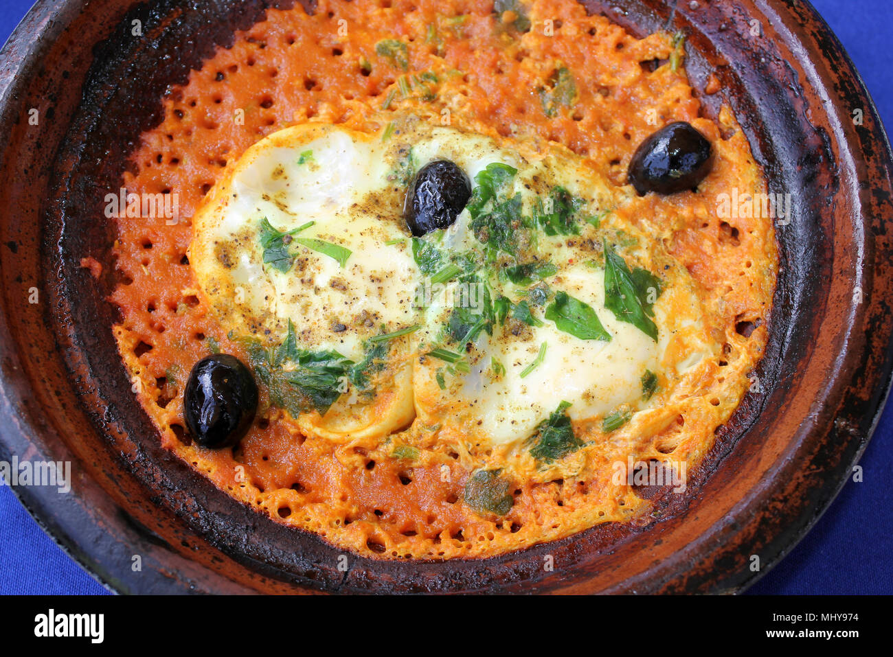 Marokkanische Berber Omelett alias Shakshuka bestehend aus Eiern, Tomaten, schwarze Oliven und Gewürzen Stockfoto