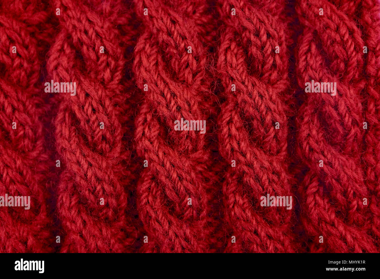 Detail der Roten handknit Spiralkabel Seil Kabel stricken Nähen als abstrakt Hintergrund Stockfoto