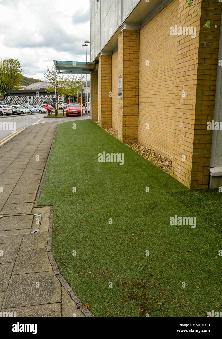 Künstliche Gras um ein Gebäude in einem Retail Park installiert Stockfoto