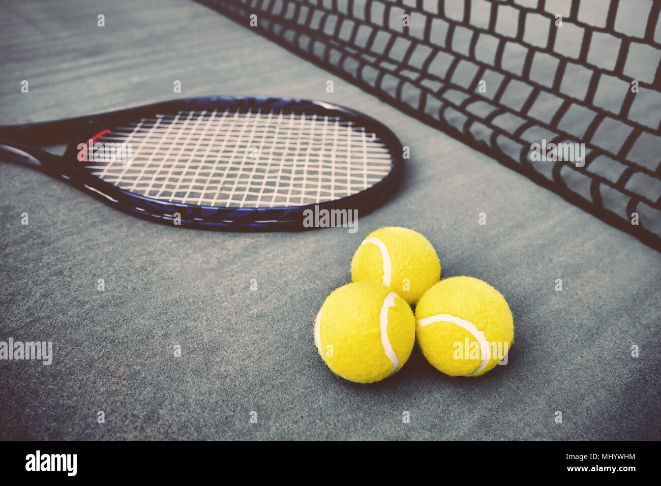 Tennisschläger, Net und drei gelbe Tennisbälle auf blauen Beton Tennisplatz Stockfoto