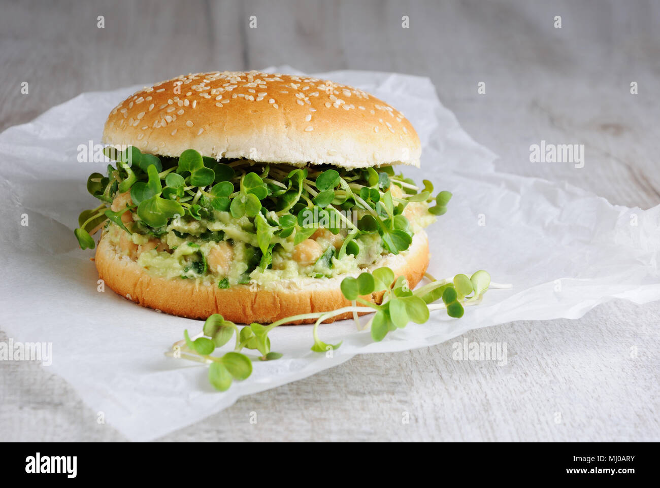 Eine vegetarische Burger aus einer Gluten-freien Brötchen mit Kichererbsen, Avocado und Kräuter, Radieschen Sprossen. Ein schnelles und gesundes Mittagessen Idee, von der sie glauben, dass Energi Stockfoto