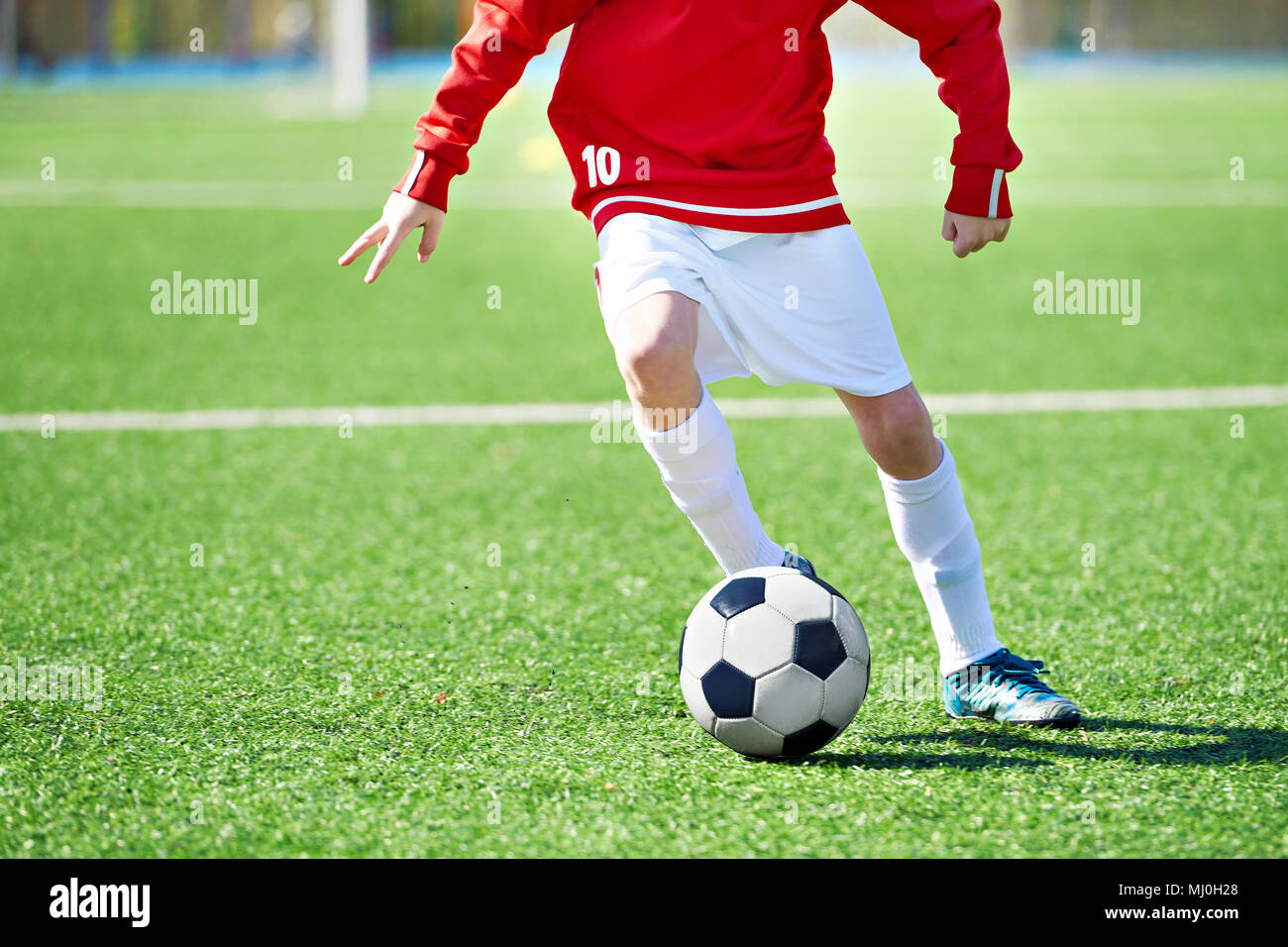 Fuß eines Kindes fußball Spieler und den Ball auf dem Fußballplatz Stockfoto