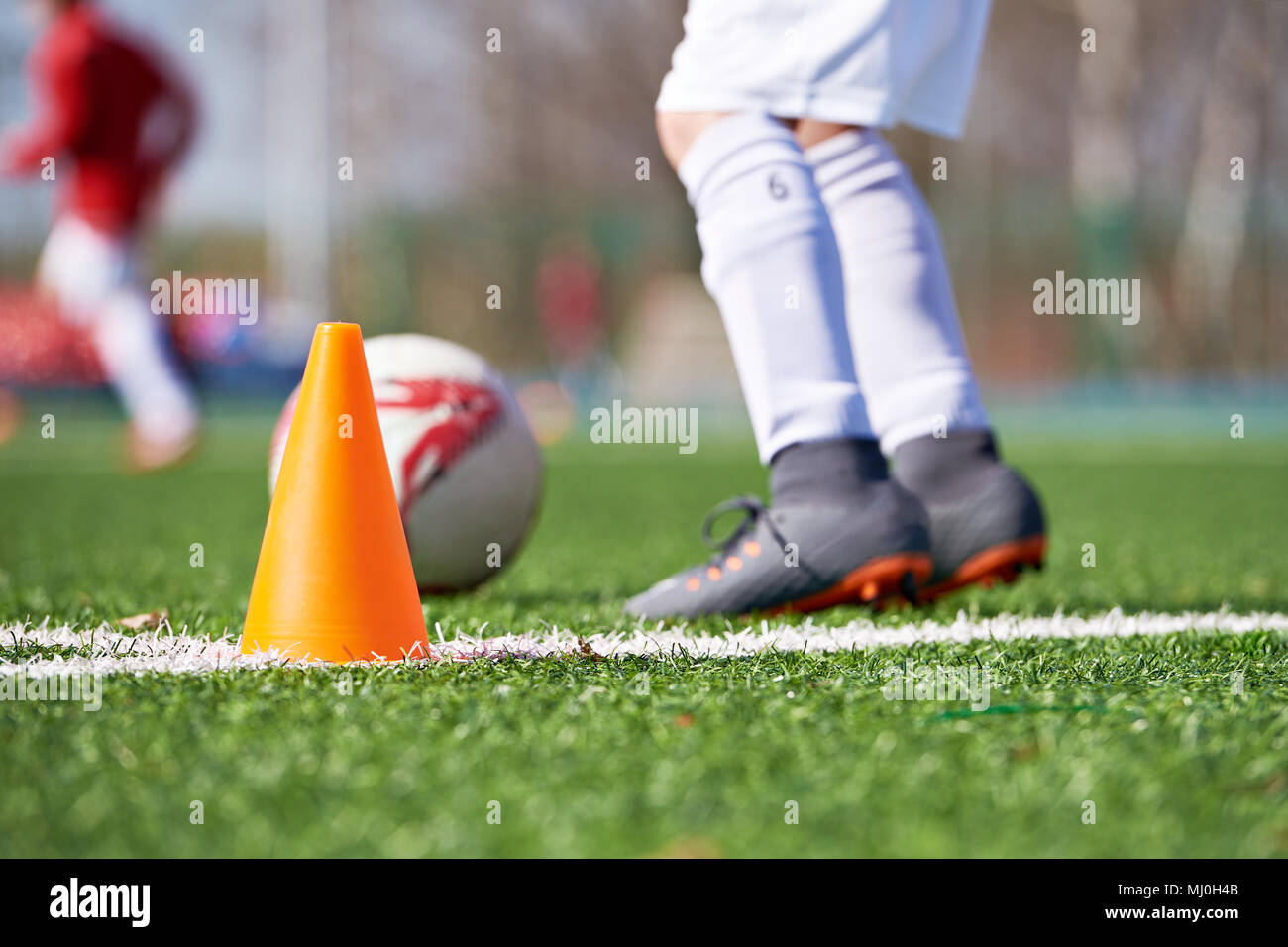 Orange Kegel für die Ausbildung von Fußball und Kind Fußball auf dem Feld Stockfoto