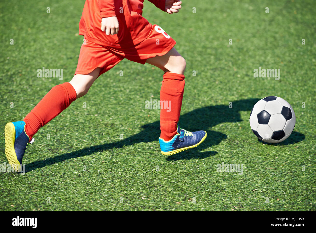 Kind fußball Spieler und den Ball auf dem Fußballplatz Stockfoto